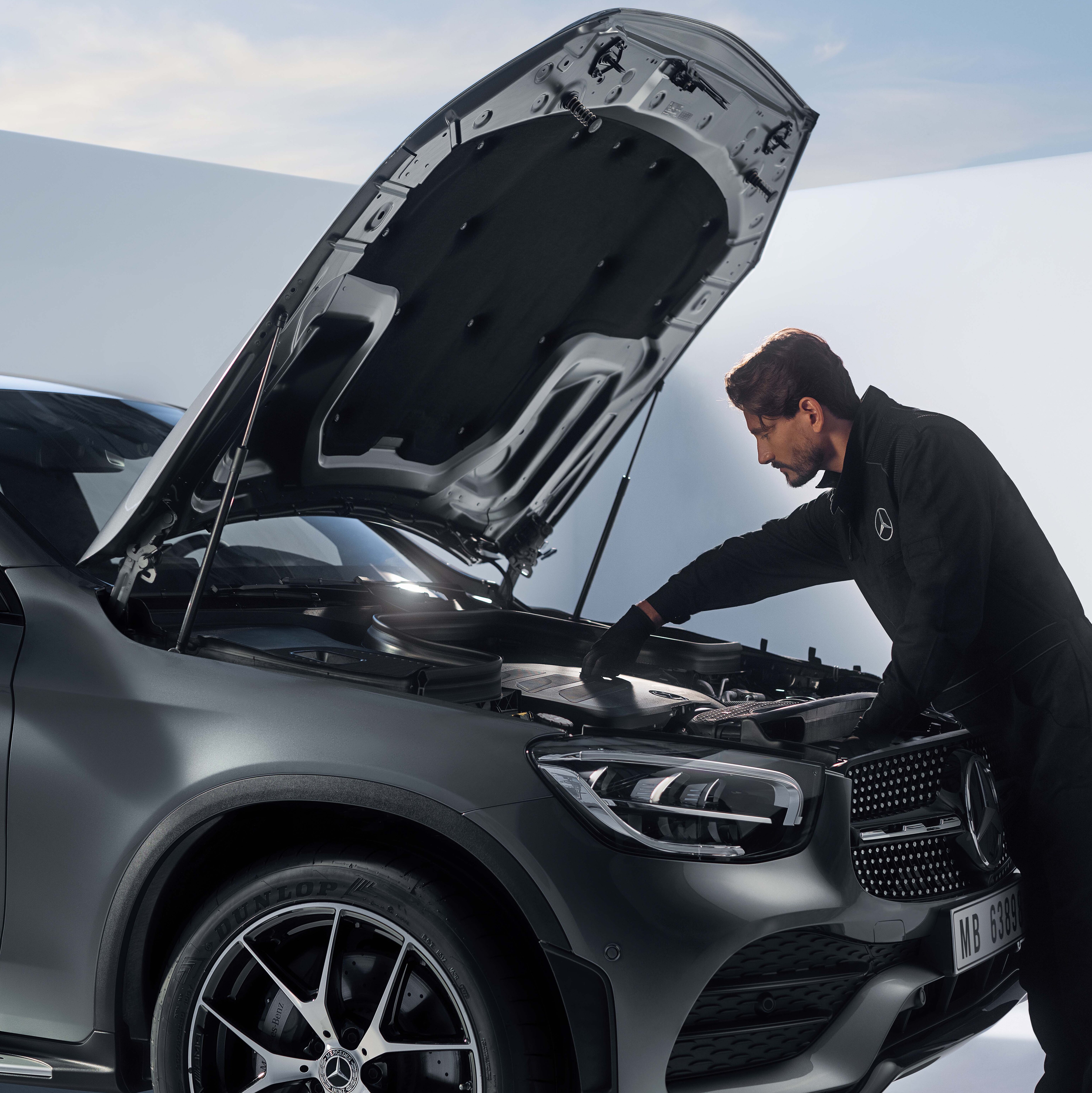 Mercedes-Benz mekaniker utför servicekontroll på elbil.