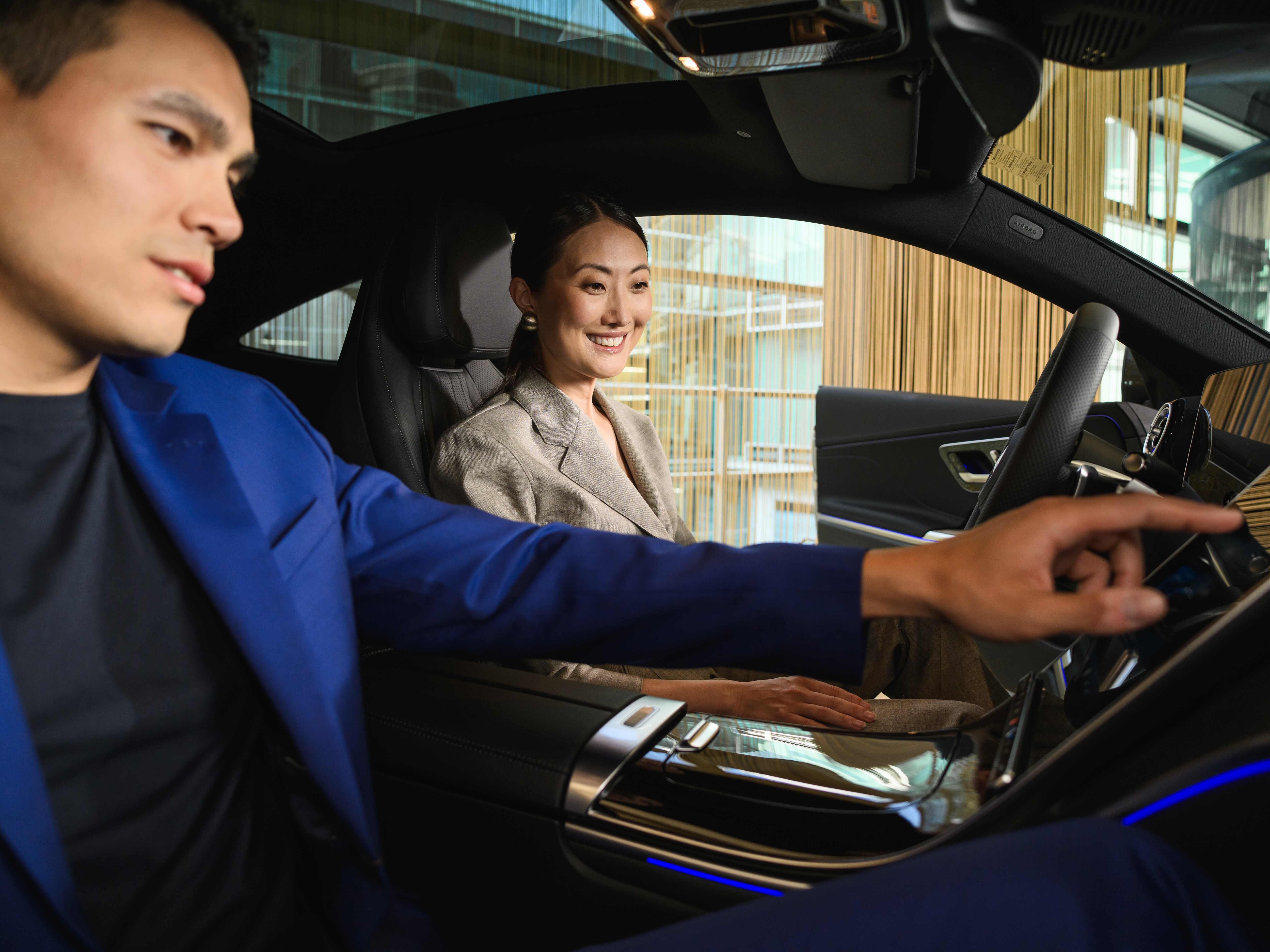 Två personer pratar bredvid en rad av olika Mercedes-Benz modeller