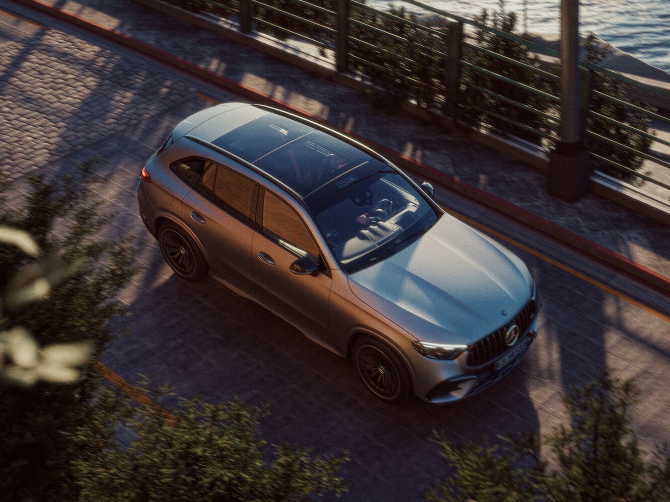 Körande Mercedes-Benz GLC sedd ovanifrån med vatten i bakgrunden.