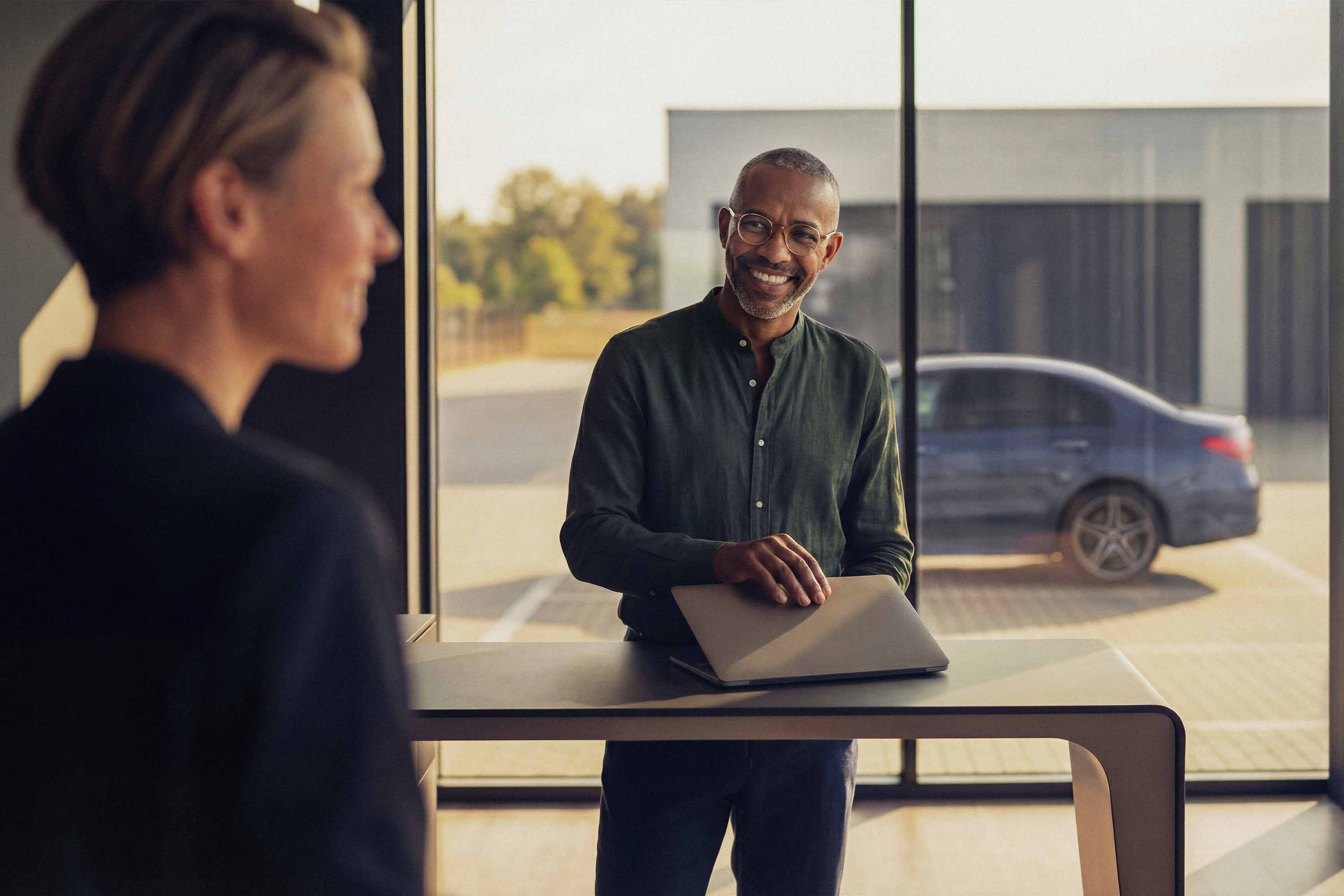 Certifierade begagnade bilar | Mercedes-Benz Mercedes-Benz-återförsäljare i ett showroom med en kund som ska titta på en begagnad bil.