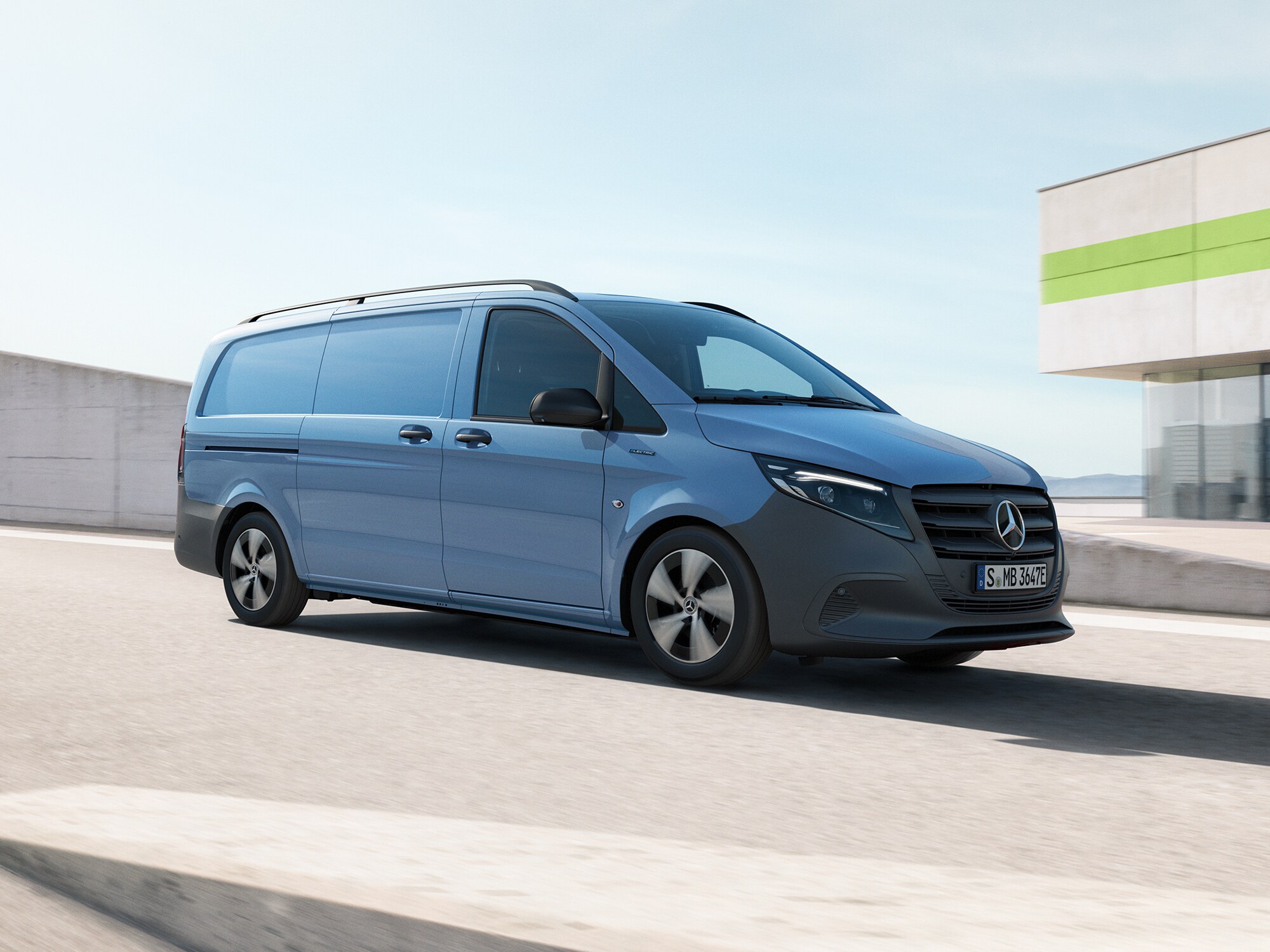 Blå Mercedes-Benz transportbil kör på parkeringsplats ovanpå en byggnad