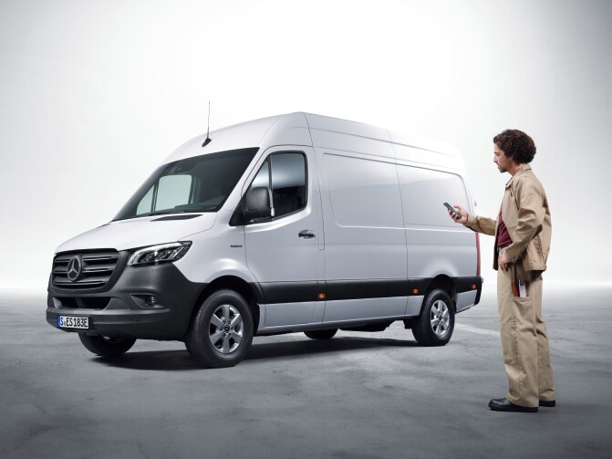 En man framför en vit Mercedes-Benz eSprinter.