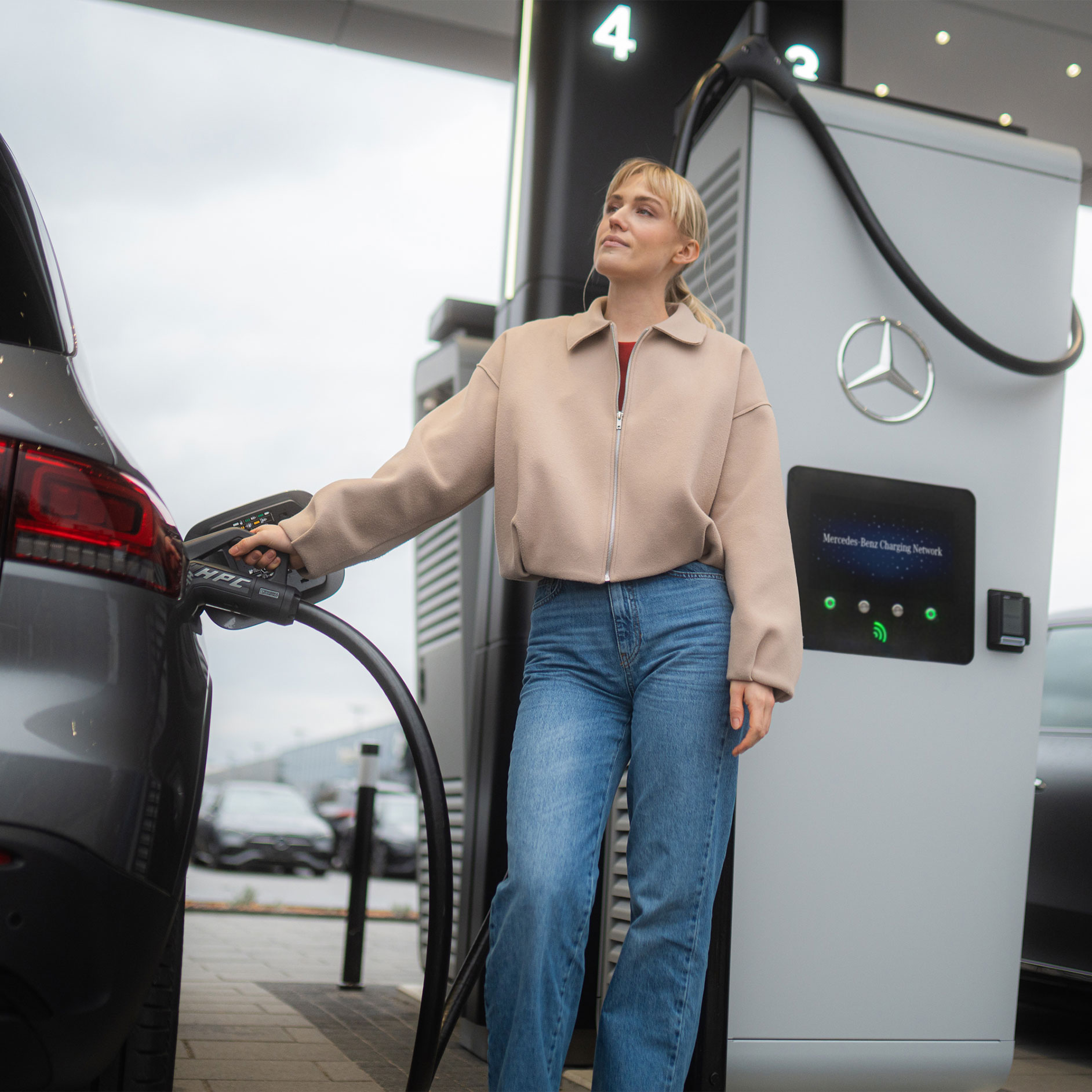 Mercedes-Benz MB.CHARGE public | Laddningsutrustning | Mercedes-Benz Kvinna laddar sin bil från Mercedes-Benz med hjälp av MB.CHARGE public.