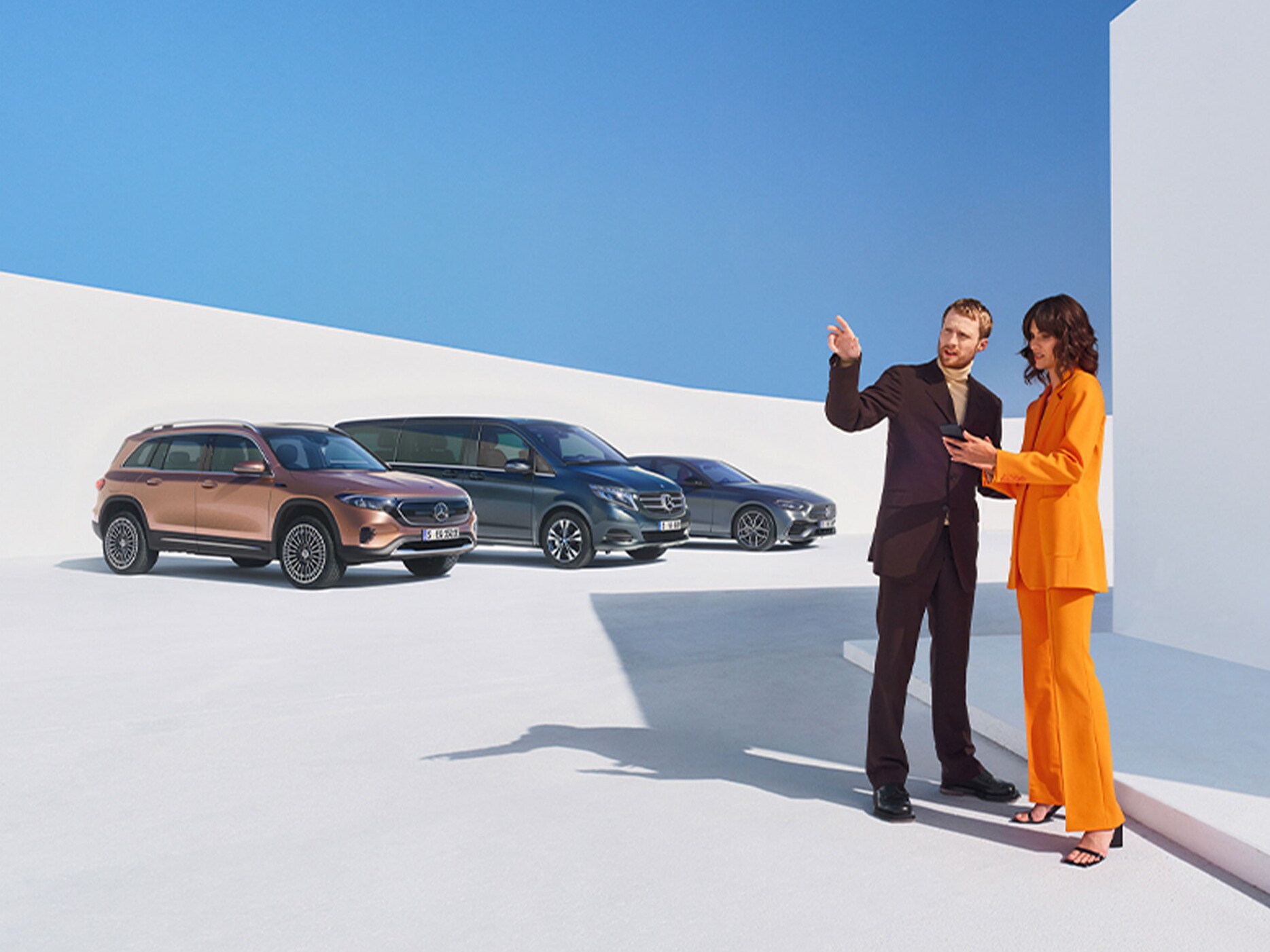 En kvinna och en man framför ett antal Mercedes-Benz-bilar