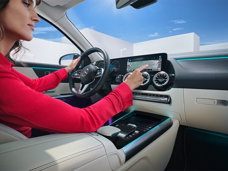 Kvinna söker efter destination i onlinesökning via MBUX i sin Mercedes-Benz.