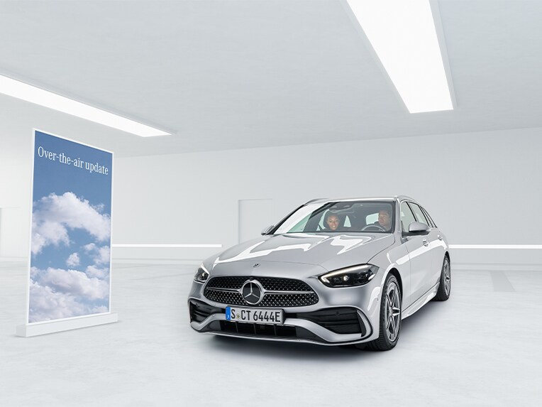 Två personer sitter i en silvrig Mercedes-Benz C-Klass.