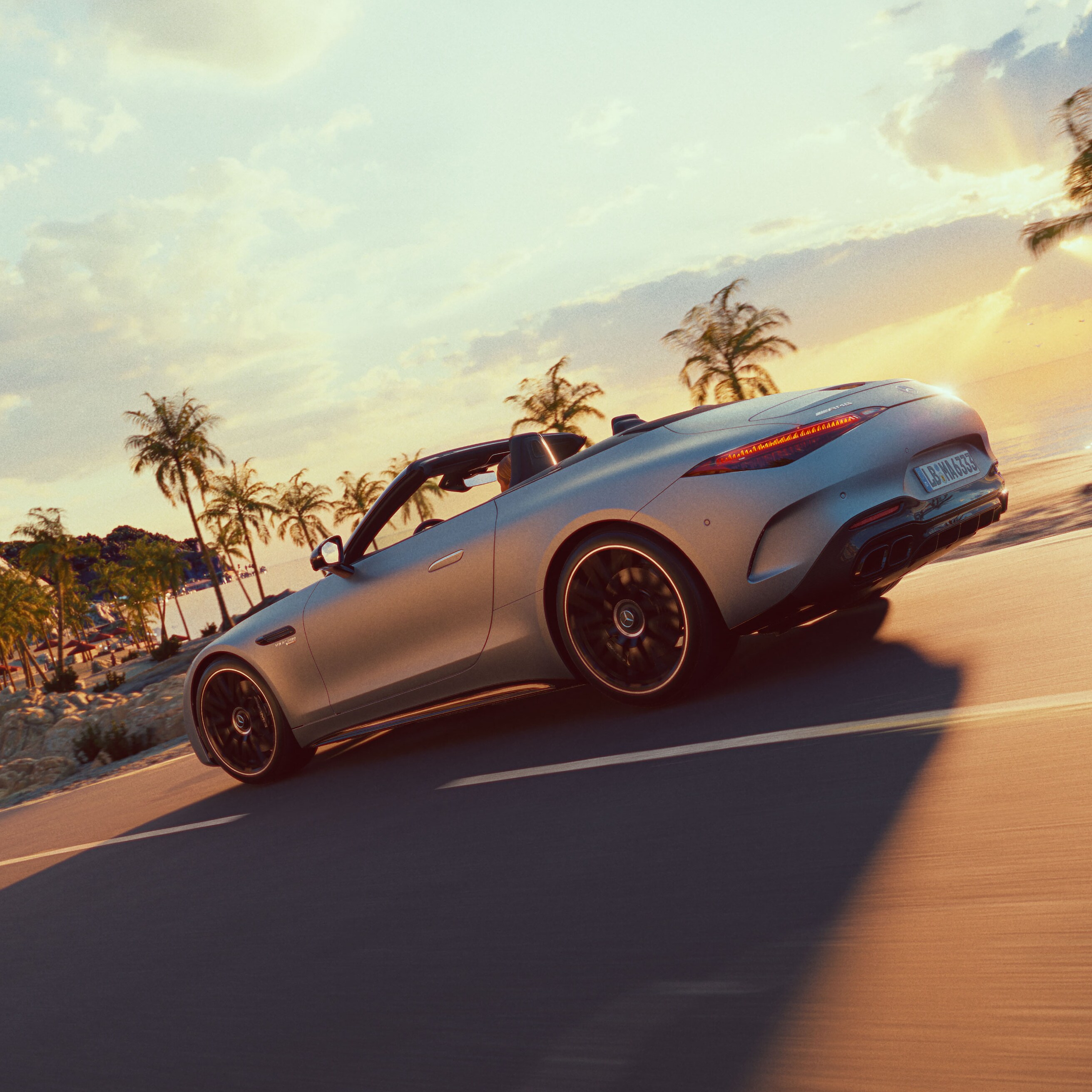 Mercedes-AMG SL Roadster sedd från sidan när den körs längs en väg med palmer i bakgrunden.