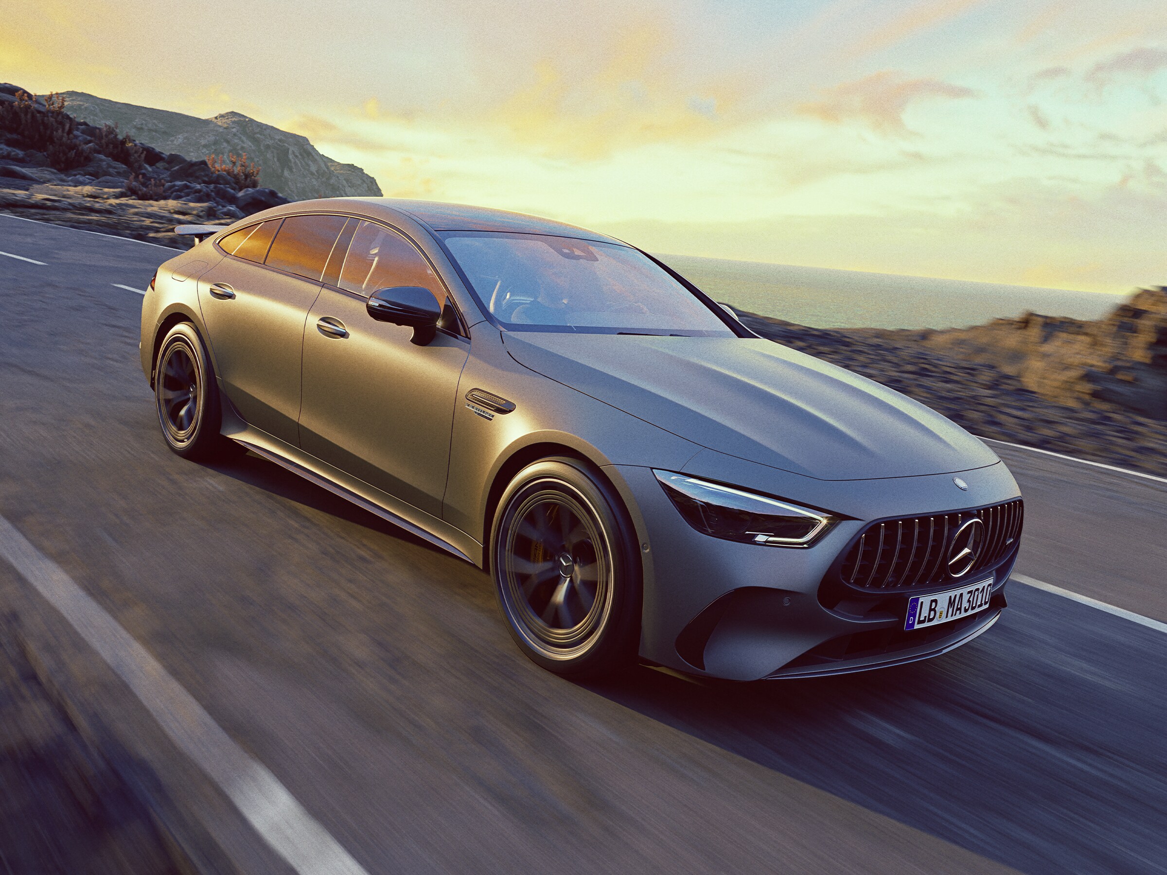 Grå Mercedes-AMG GT 4-dörrars Coupé kör genom en bergsrutt.