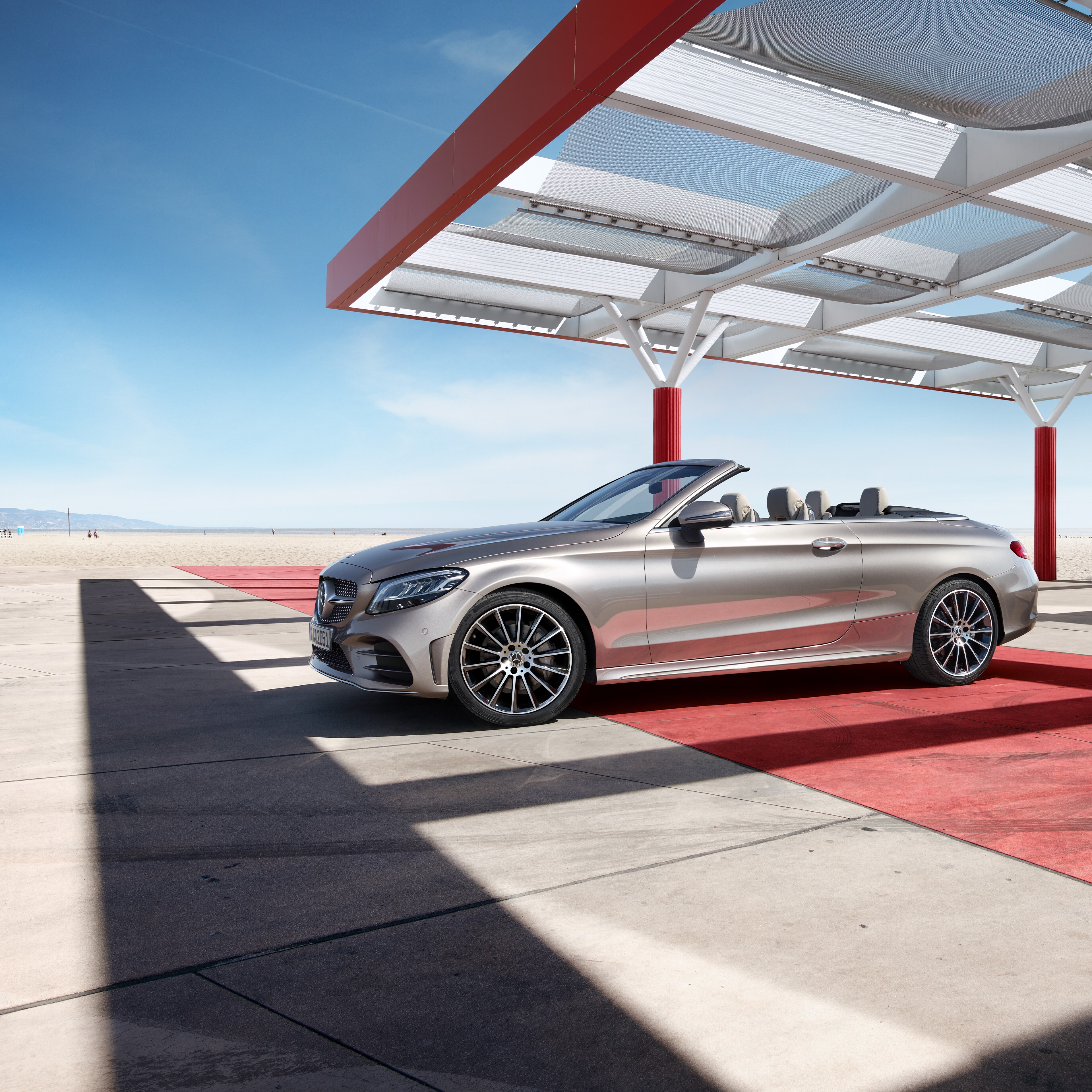 C-Klass Cabriolet från Mercedes-Benz parkerad på strand.