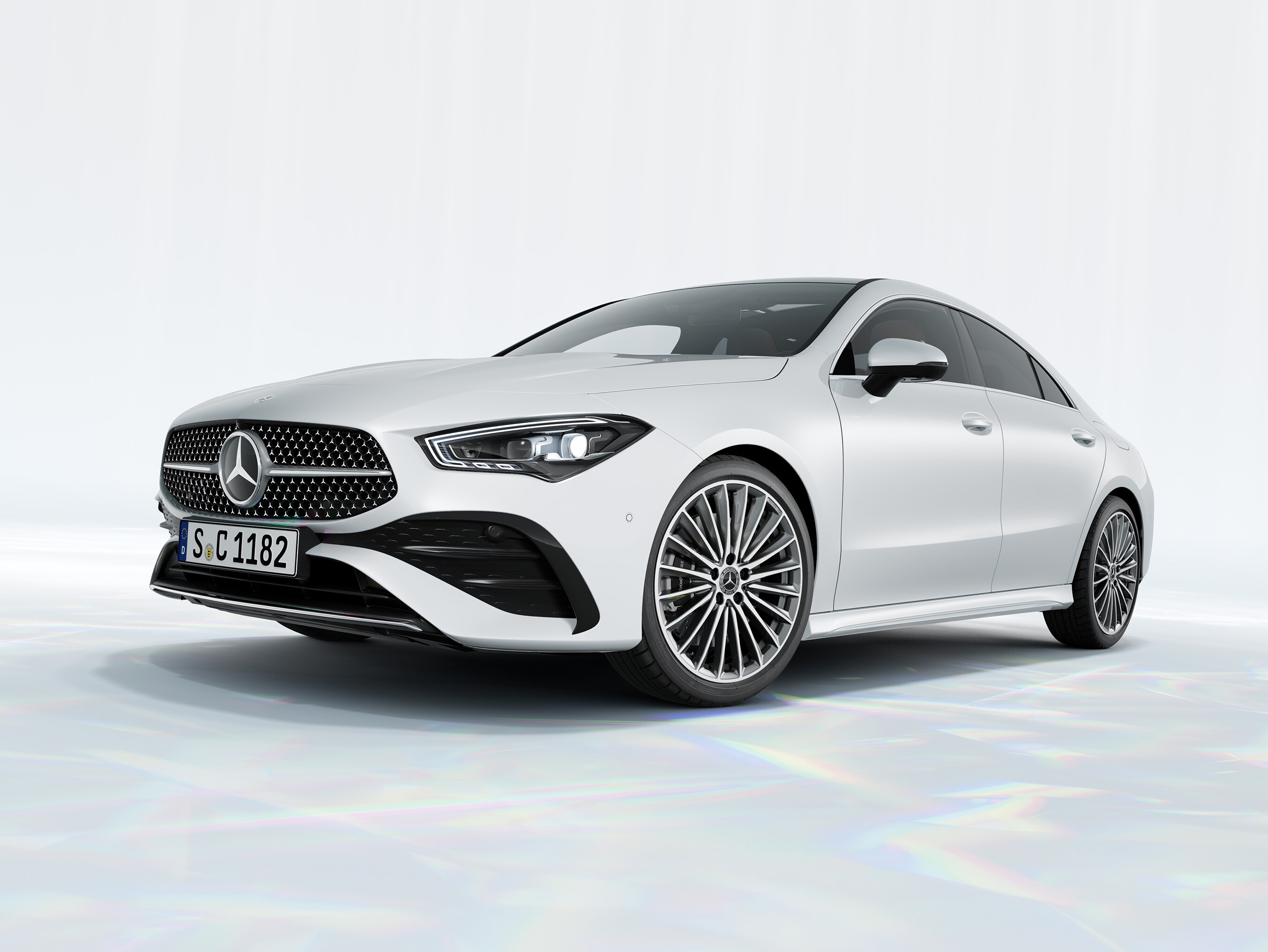 En vit Mercedes-Benz CLA Coupé Special Edition parkerad på marmorliknande sten