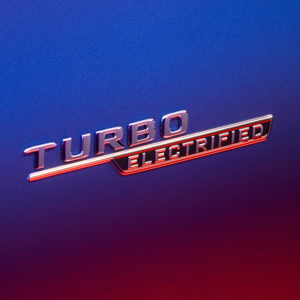 TURBO E PERFORMANCE-emblem på framskärmen, upplyst av rött ljus.