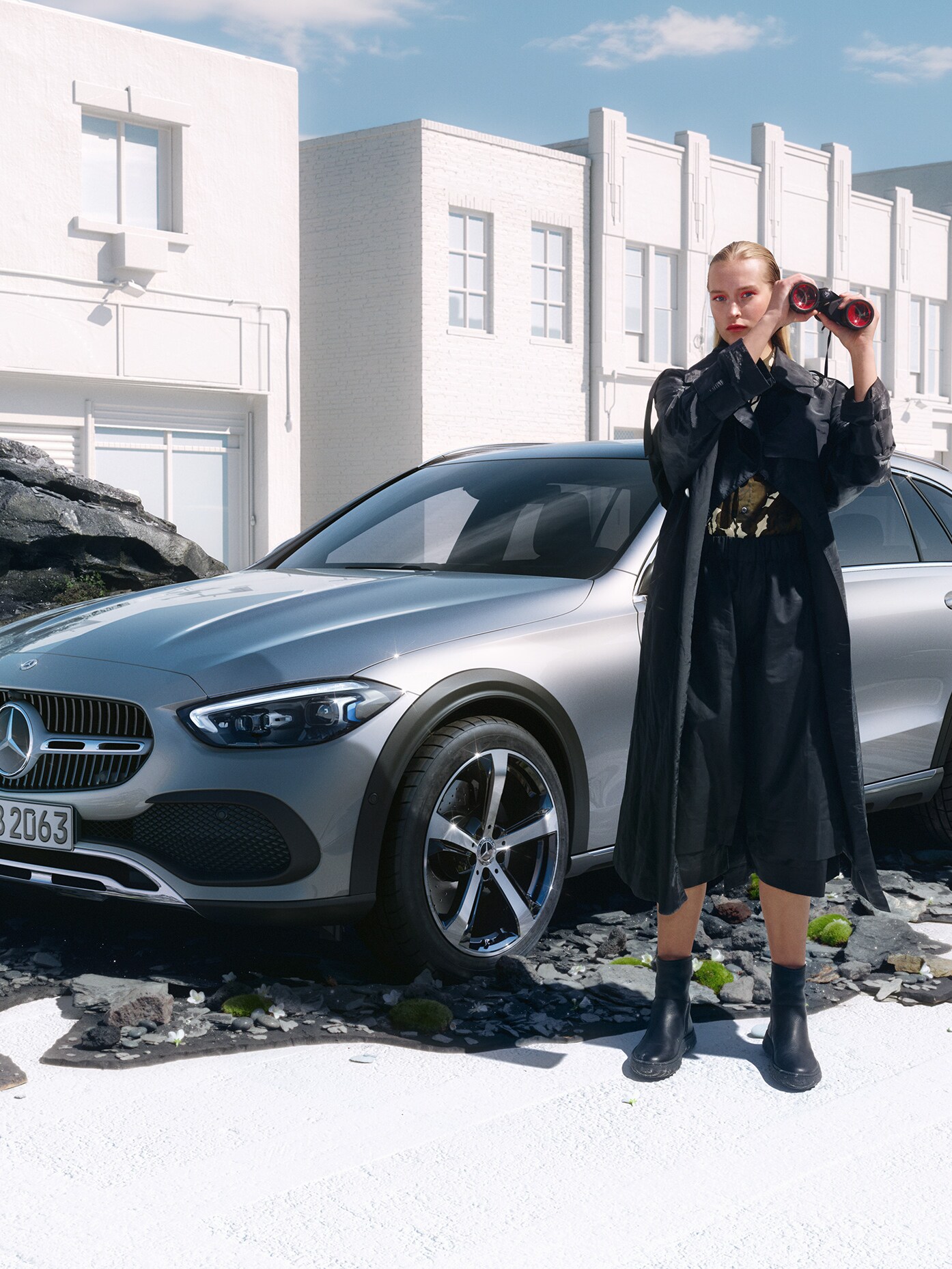 Kvinna med kikare står framför C-Klass Kombi från Mercedes-Benz