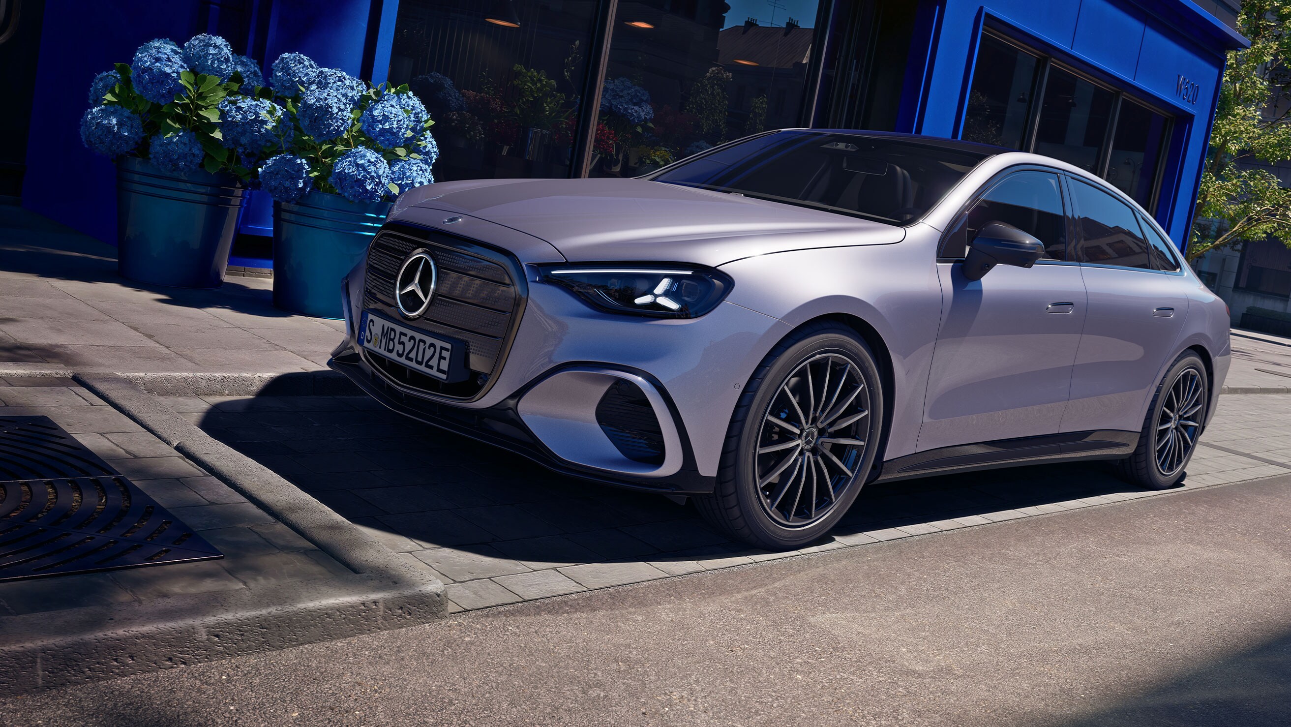 Nya elektriska Mercedes-Benz C-Klass parkerad framför lavendelblå butiksfasad