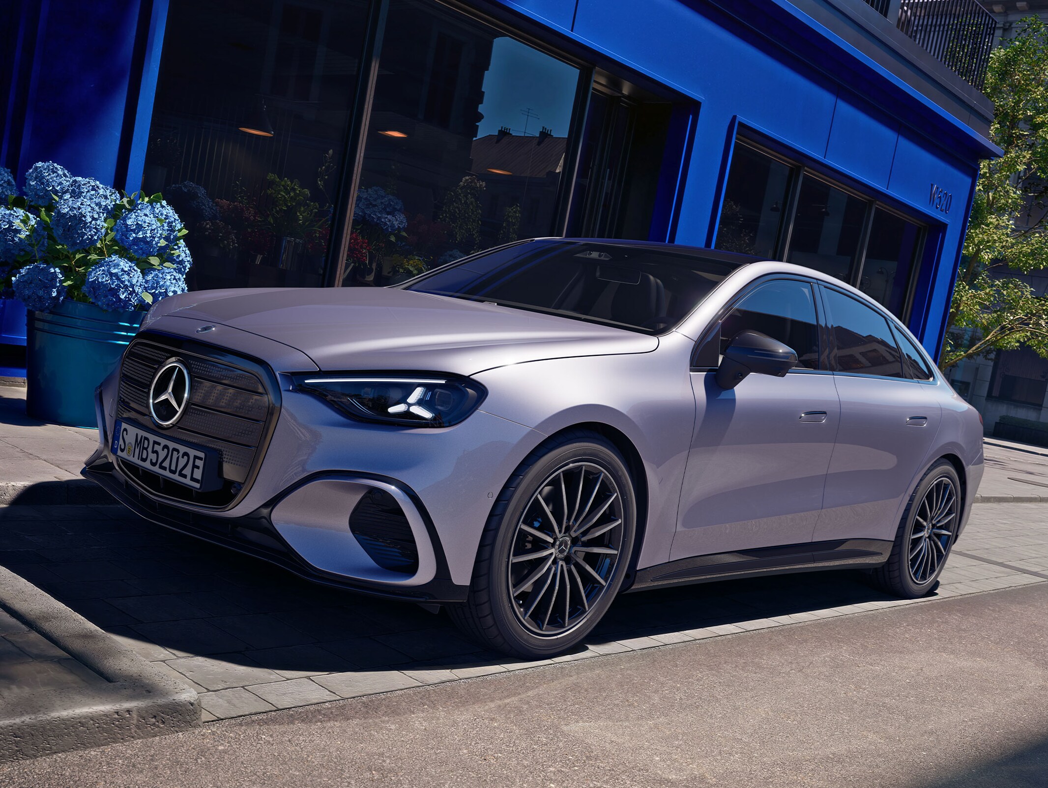 Helelektriska Mercedes-Benz C-Klass parkerad framför en blå butiksfasad