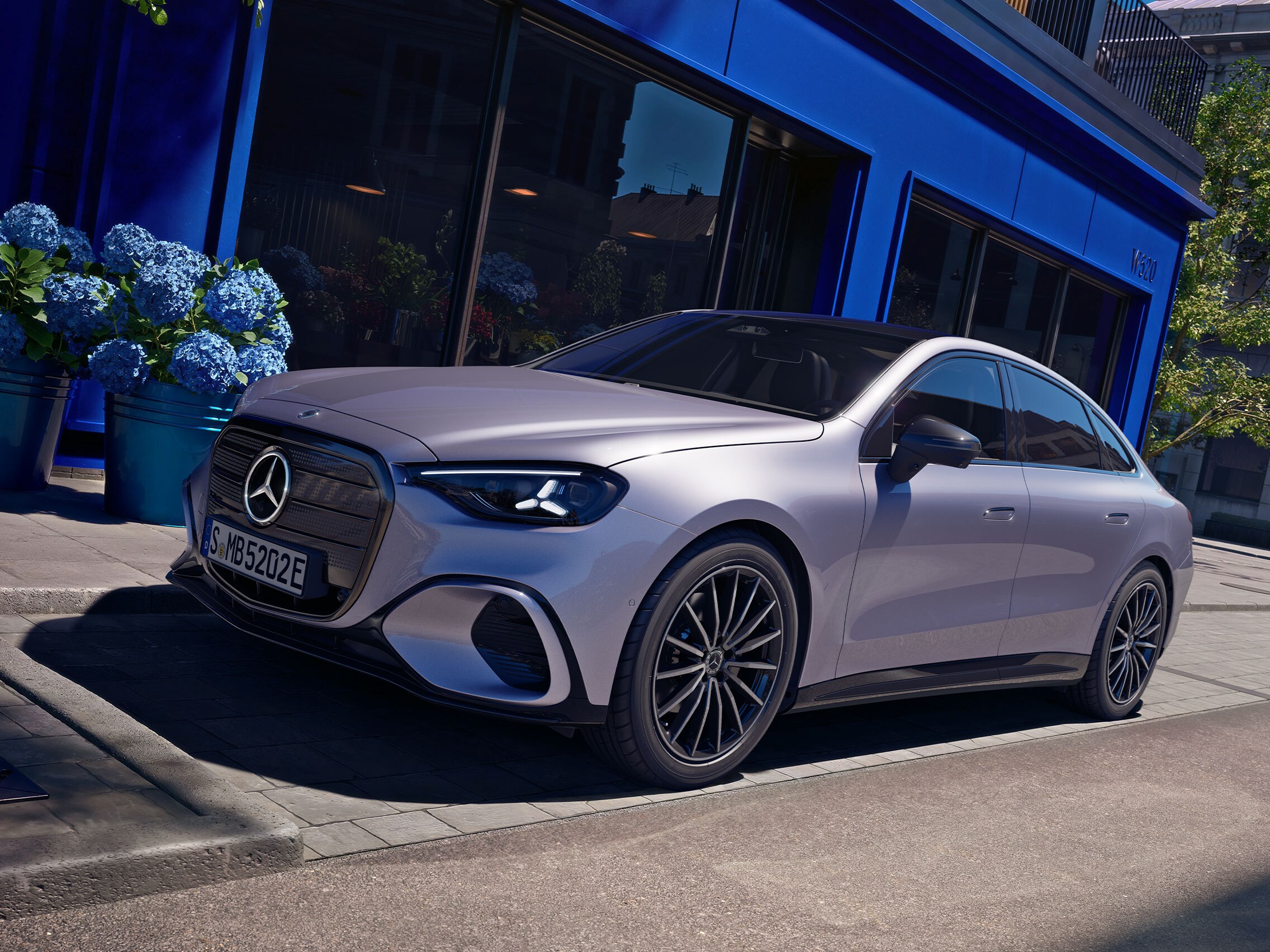 Elektrisk C-Klass från Mercedes-Benz parkerad utanför en butik.