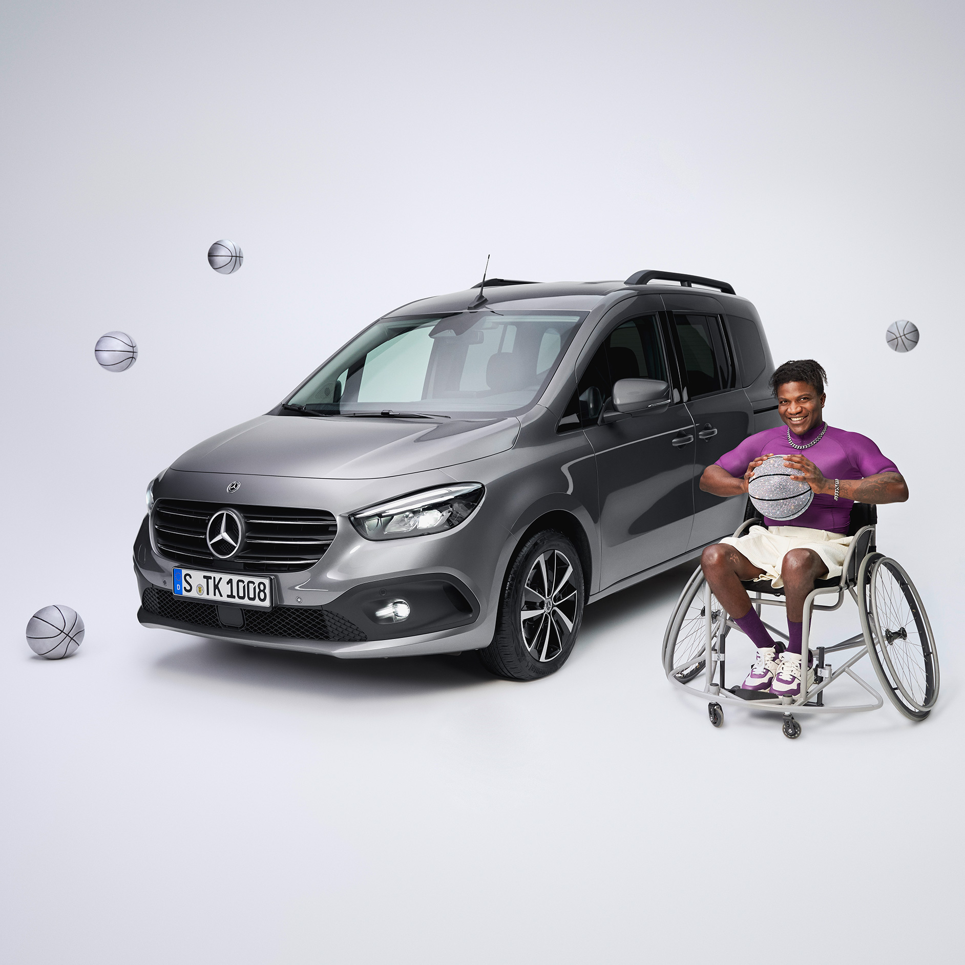 Handreglage | Körhjälpmedel | Mercedes-Benz Sidovy av en funktionshinderanpassad T-Klass och en basketspelare i rullstol.