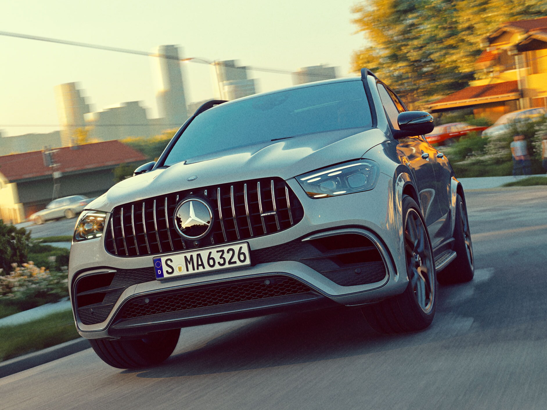 GLE SUV från Mercedes-AMG sedd framifrån kör på en väg med skylinen i bakgrunden.