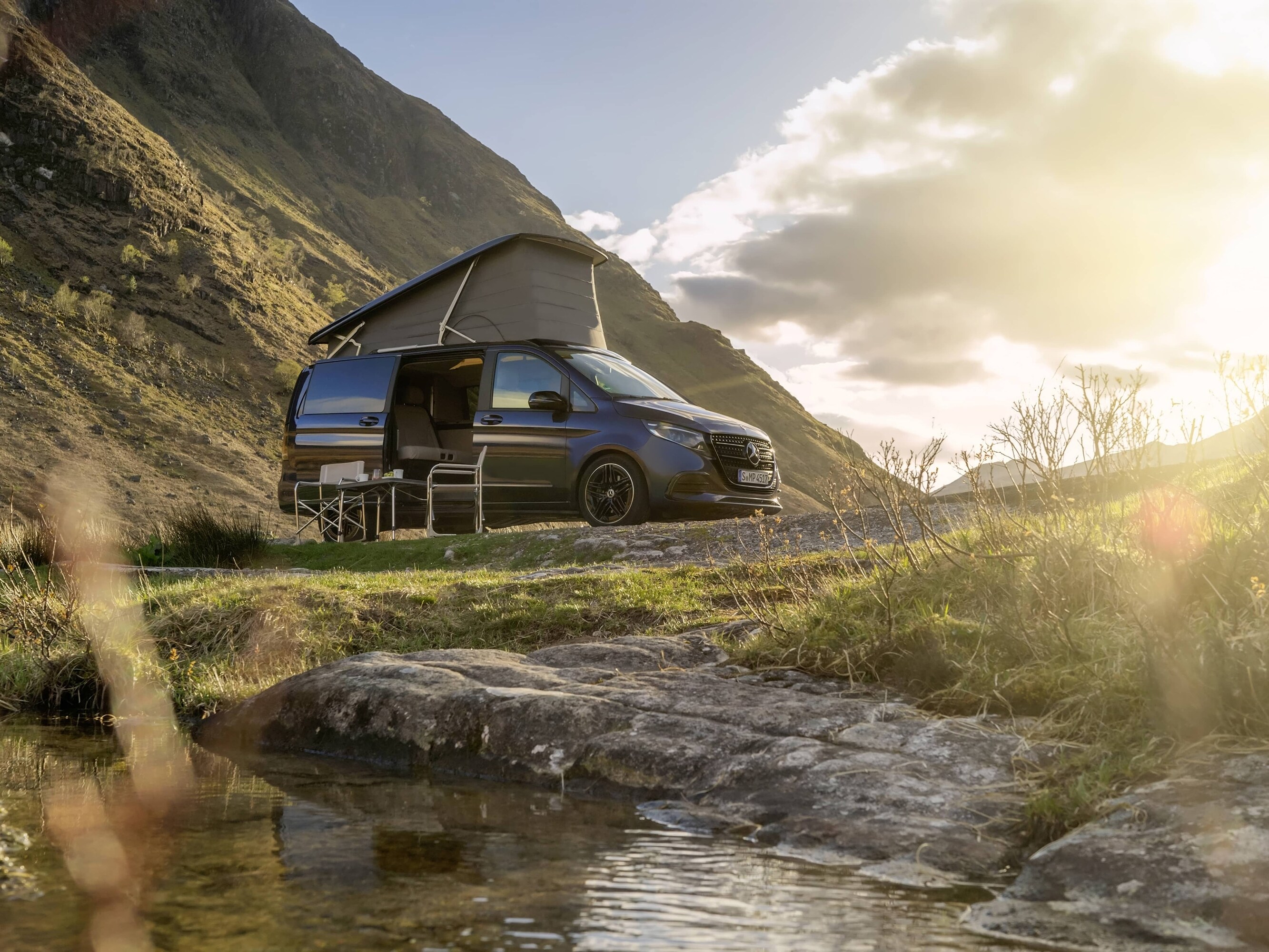 Mercedes-Benz Marco Polo-camper med pop-up-tak i ett naturskönt bergslandskap som visar friluftsäventyr och vanlife-frihet.