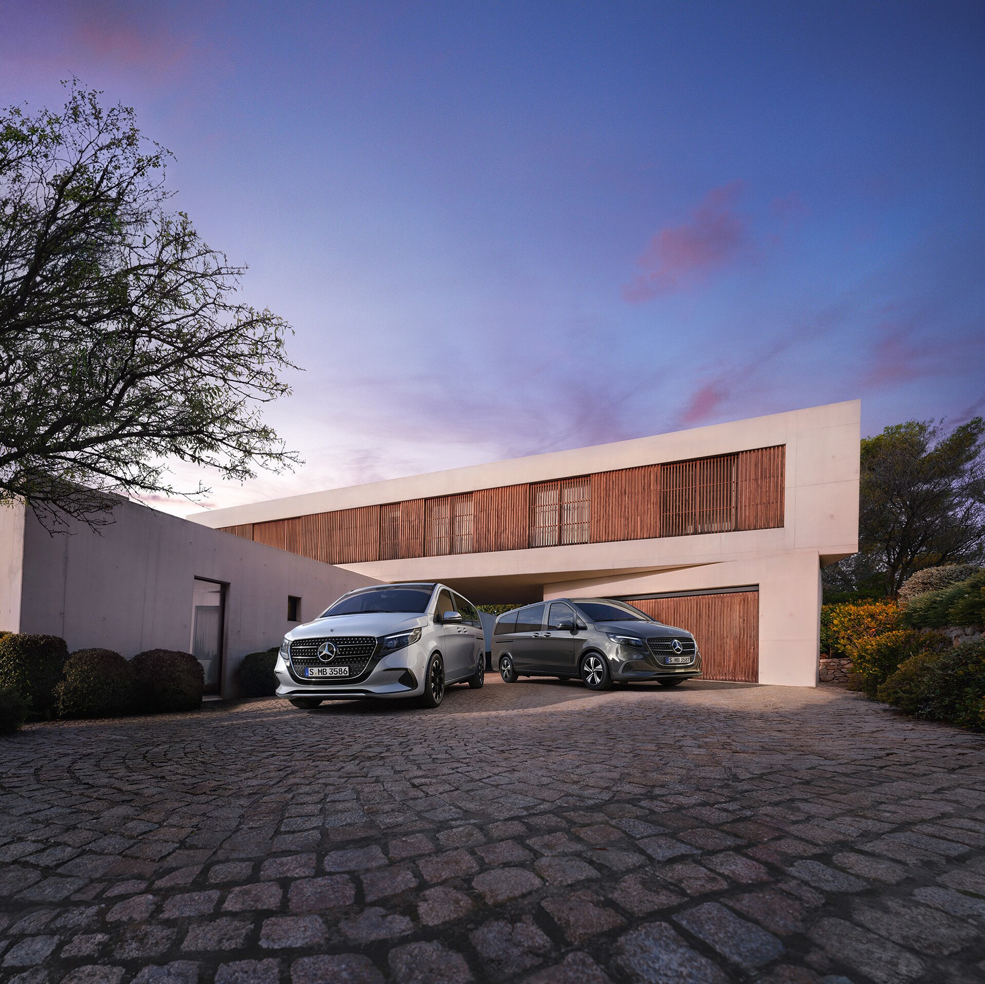 Mercedes-Benz V-Klass framför ett modernt lyxhus i skymningen.