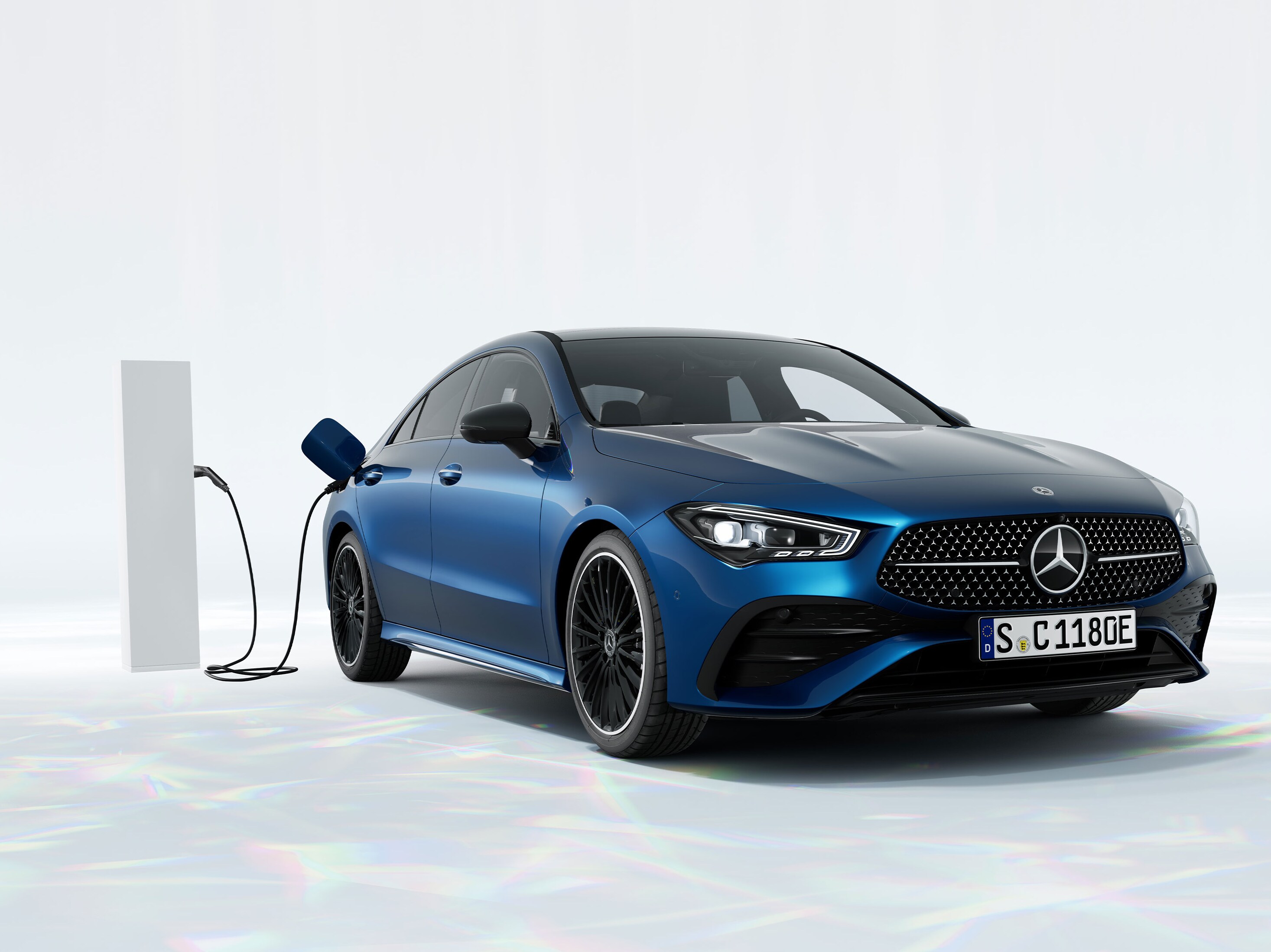 En blå Mercedes-Benz CLA laddhybrid laddas vid en laddstolpe