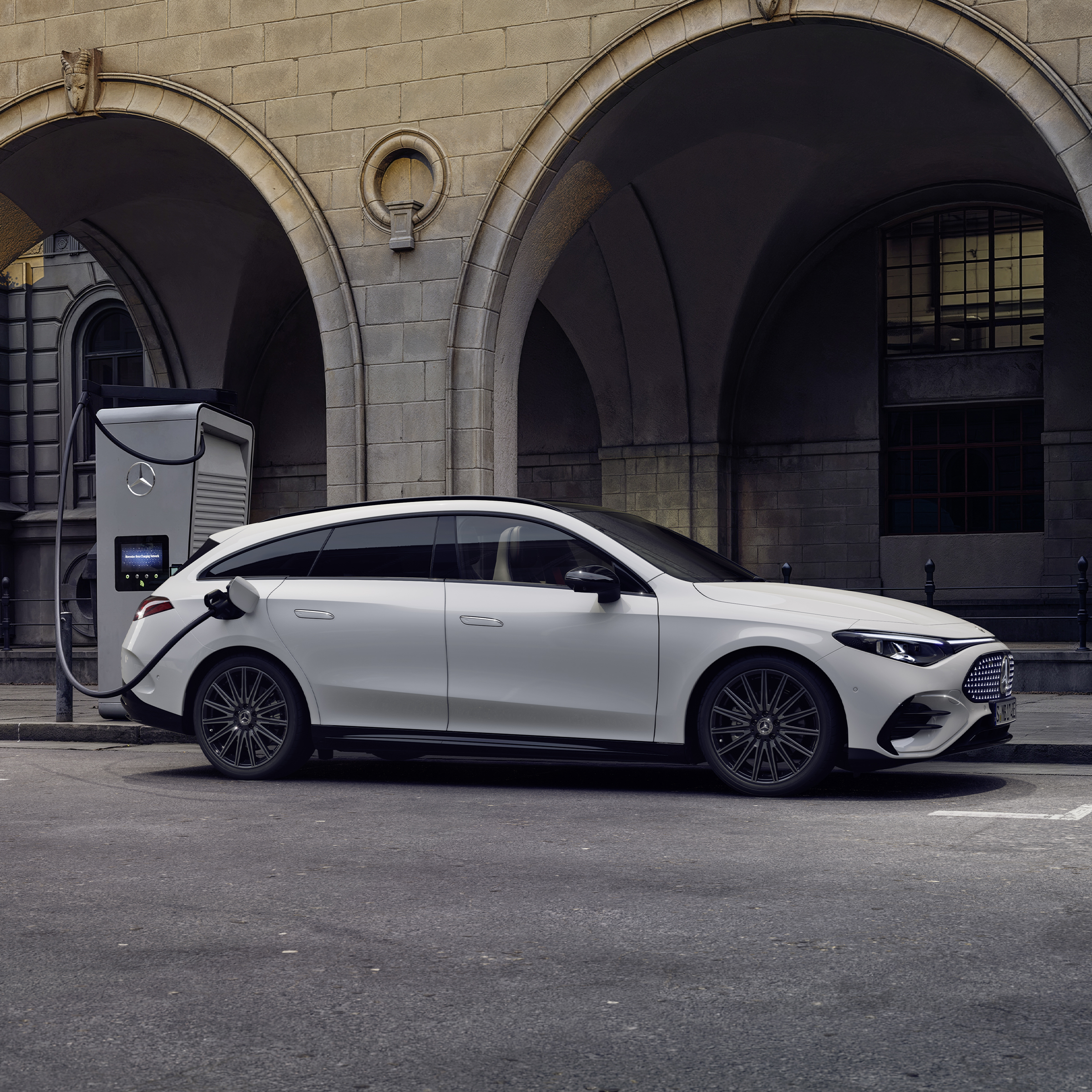 Elbilar | Mercedes-Benz Vit Mercedes-Benz CLA laddas vid en offentlig laddstation.