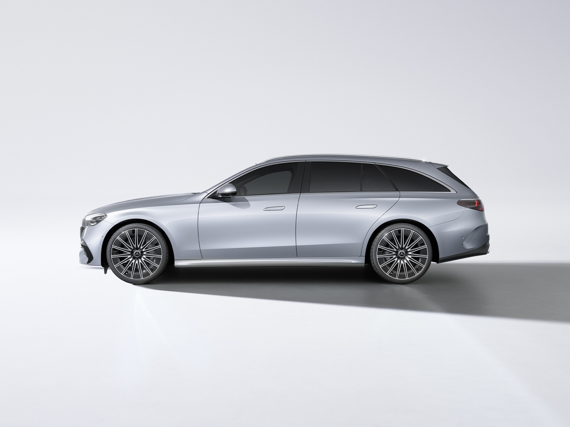 Silverfärgad E-klass kombi från Mercedes-Benz sedd från sidan.