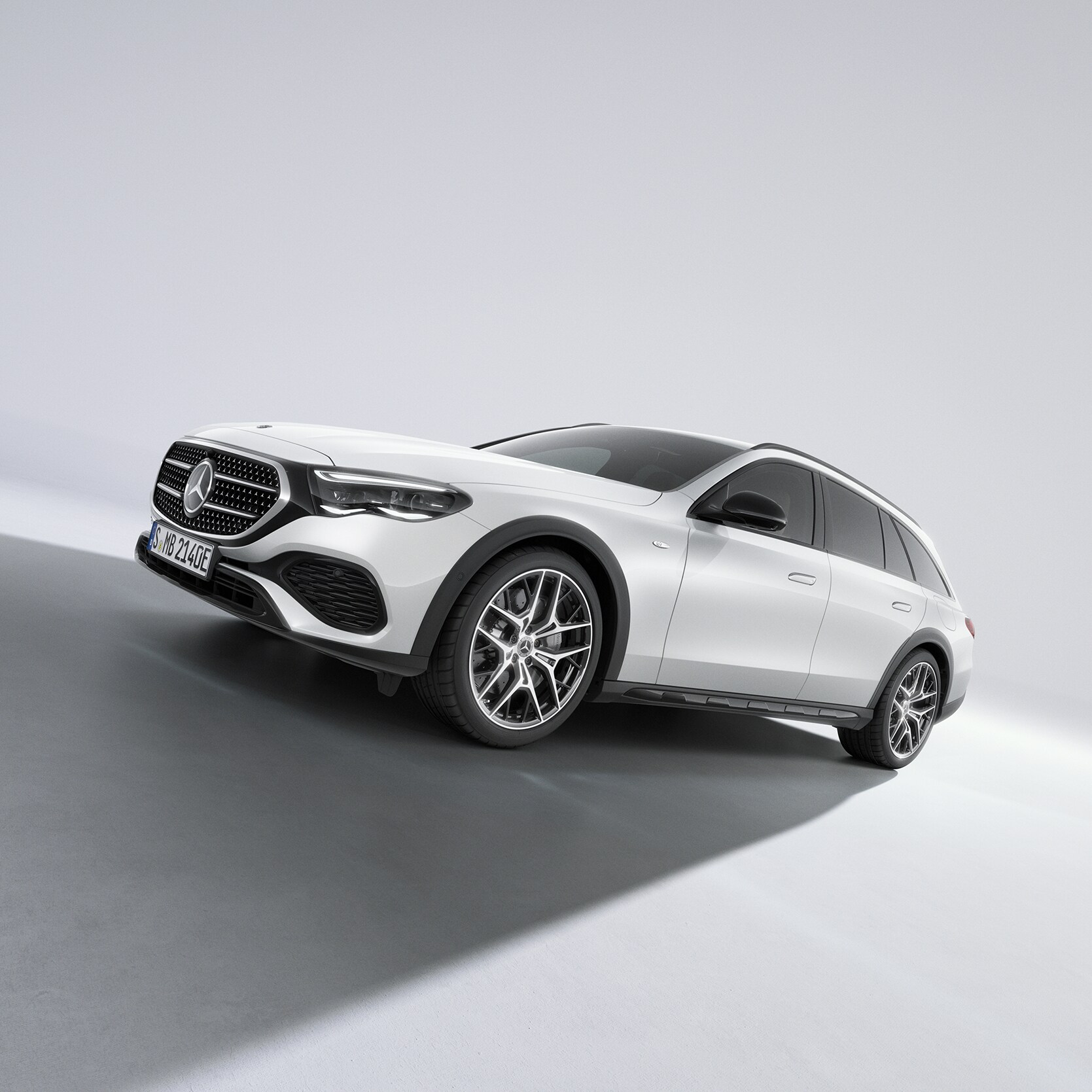Vit Mercedes-Benz E-Klass All-Terrain fotograferad på väg uppför sluttningen