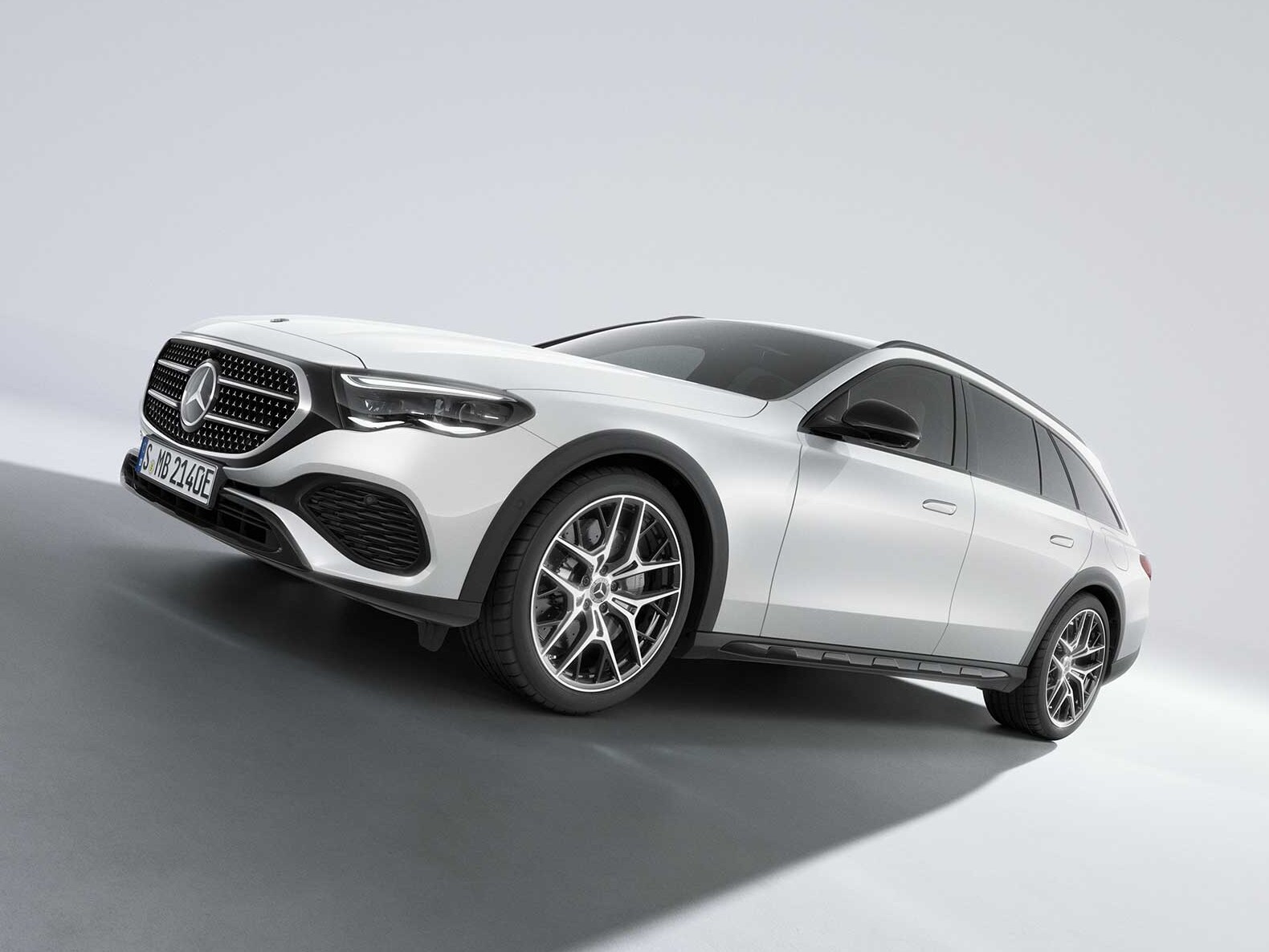 Vit Mercedes-Benz E-Klass All-Terrain fotograferad på väg uppför sluttningen