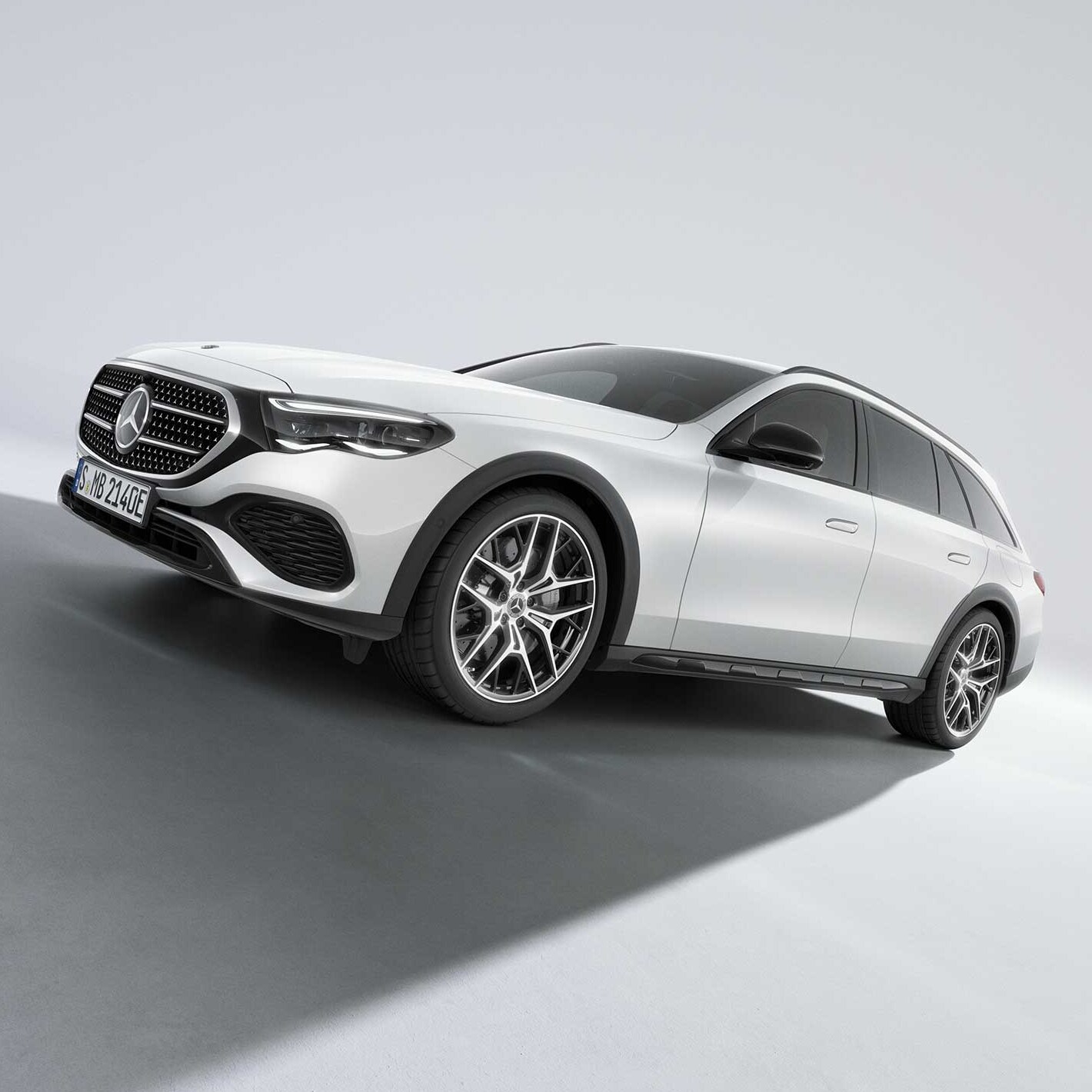 Vit Mercedes-Benz E-Klass All-Terrain fotograferad på väg uppför sluttningen