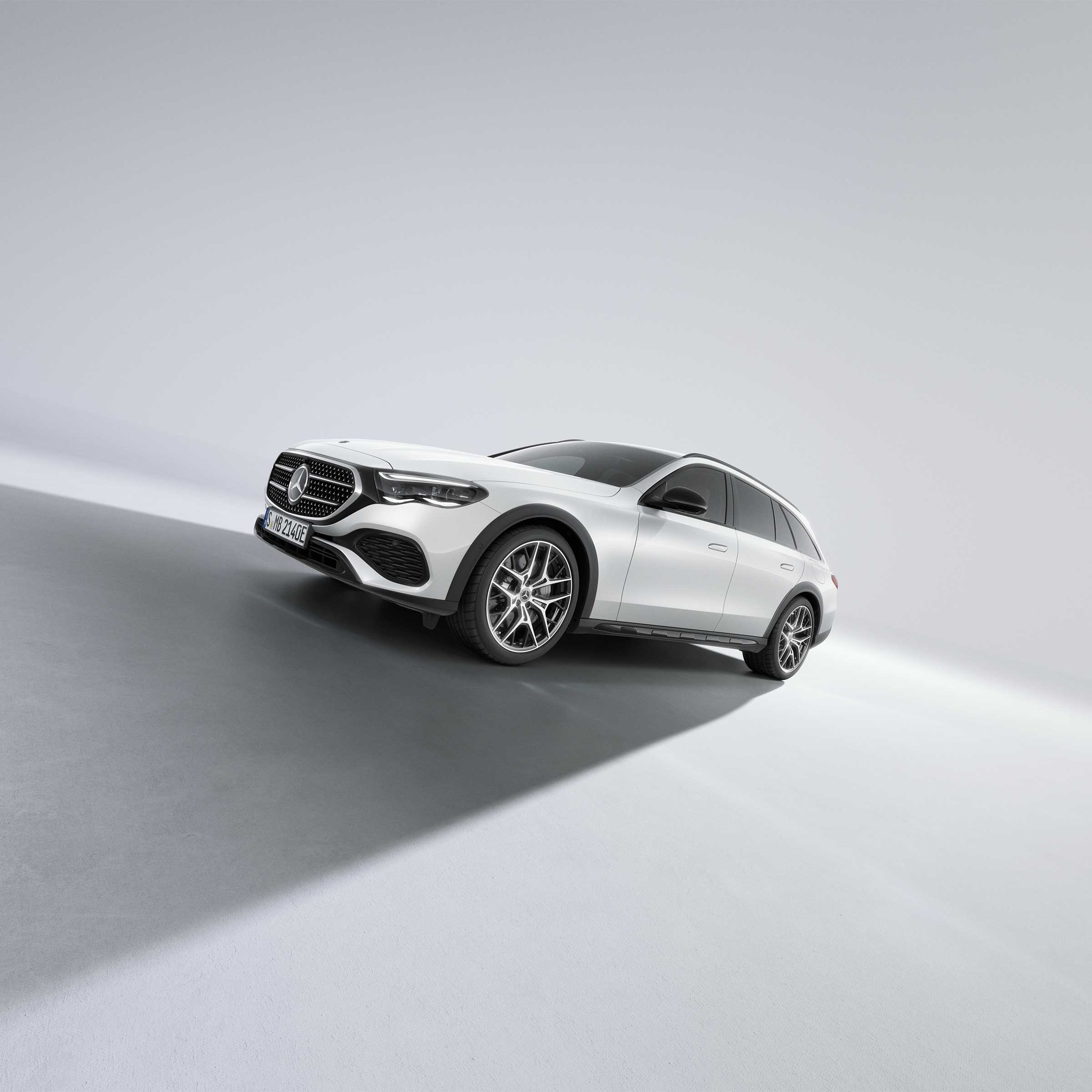 Vit Mercedes-Benz E-Klass All-Terrain fotograferad på väg uppför sluttningen