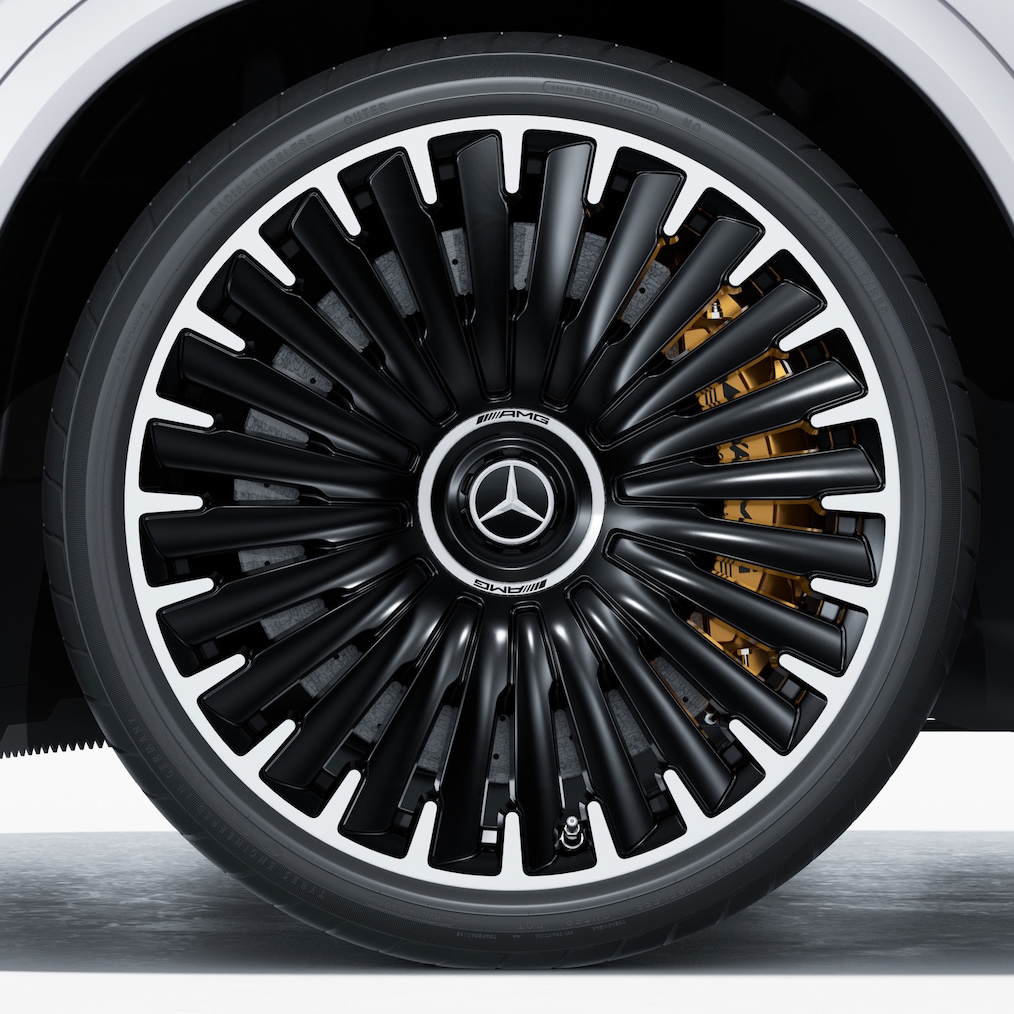 Närbild av en AMG lättmetallfälg med AMG-högprestandabromssystem i keramikkompositmaterial som lyser igenom.