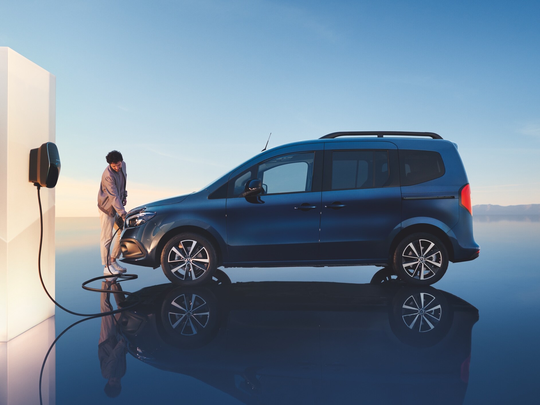 Man laddar sin EQT från Mercedes-Benz vid en wallbox.