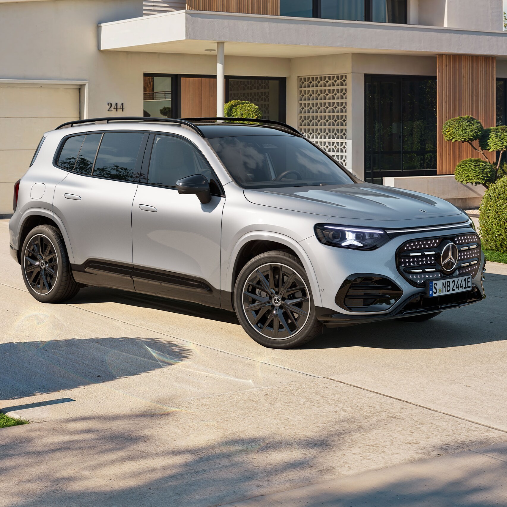 Den nya helelektriska GLB från Mercedes-Benz framför ett hus med garage