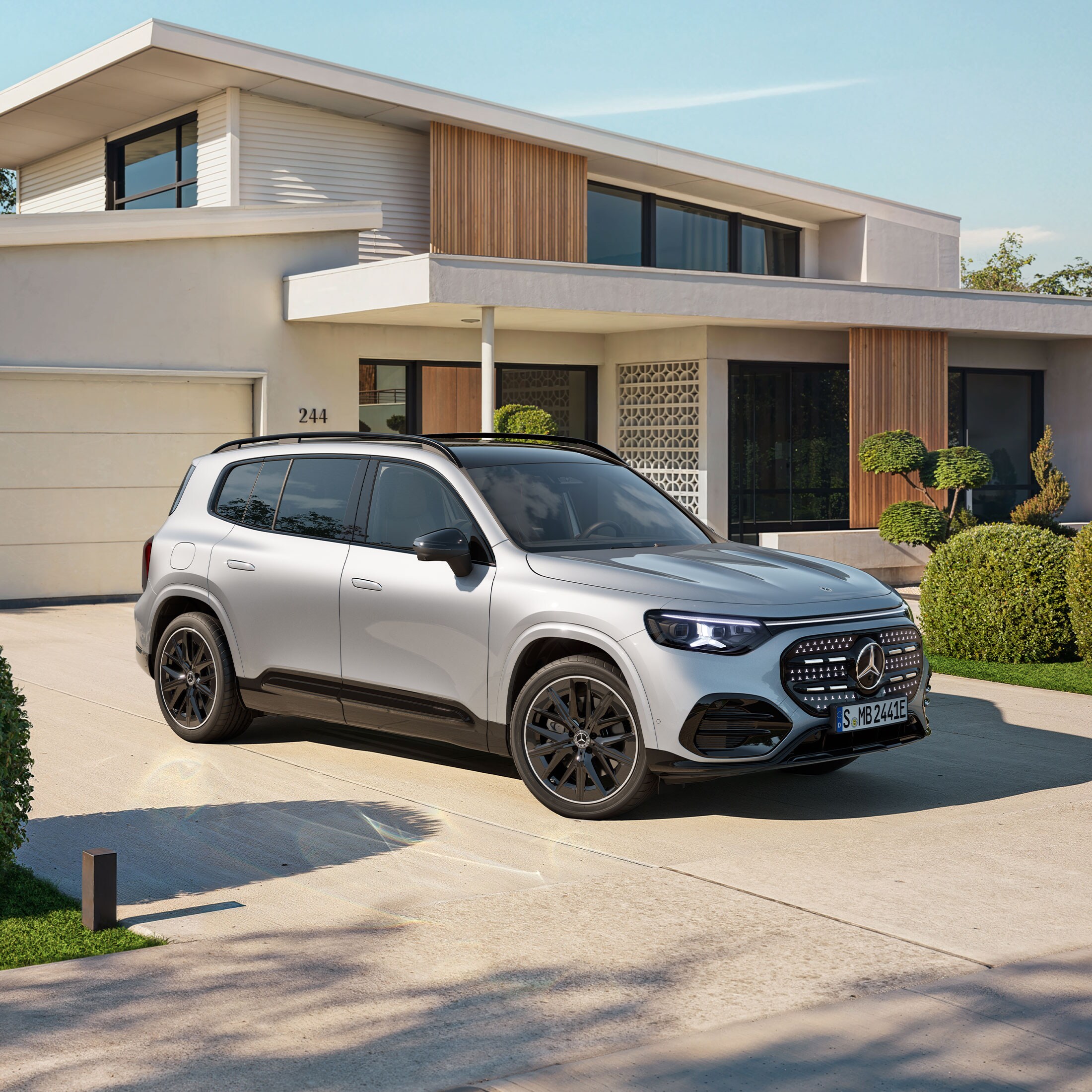 Den nya helelektriska GLB från Mercedes-Benz framför ett hus med garage