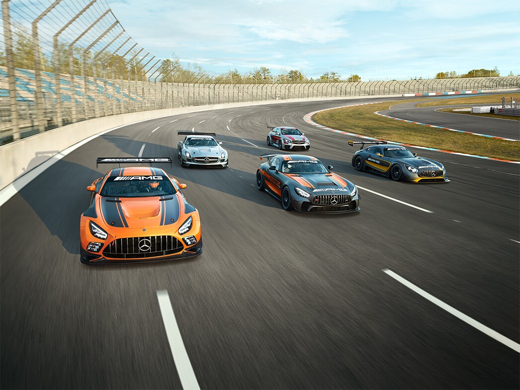 Flera Mercedes-AMG GT-bilar kör på en racerbana.