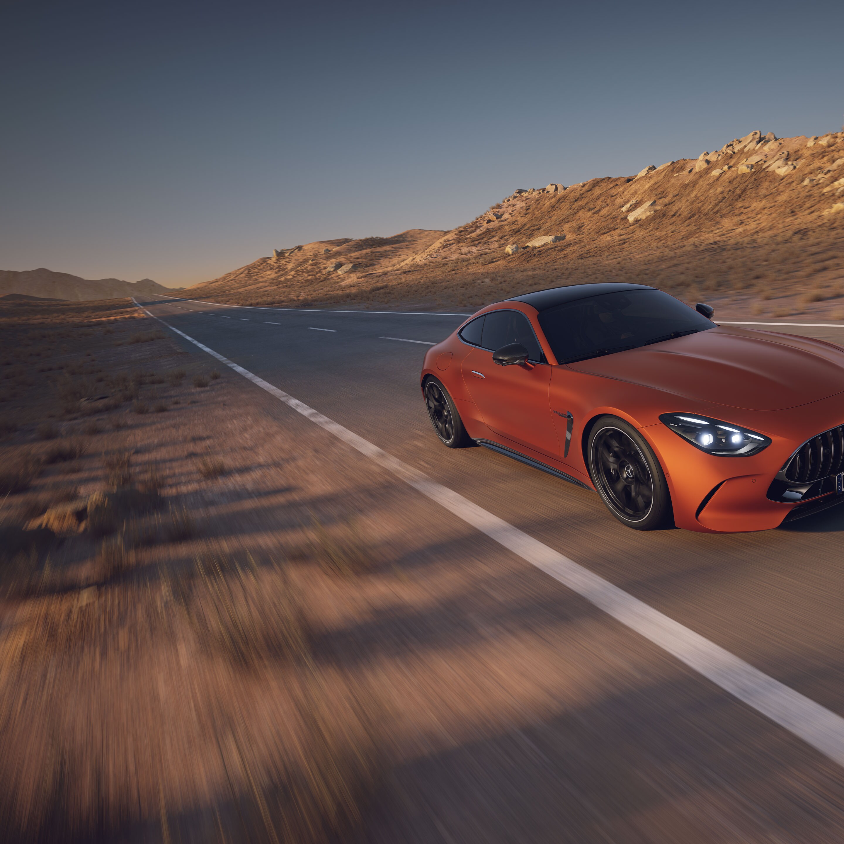 Orange Mercedes-AMG GT Coupé från Mercedes-Benz kör genom en öken.