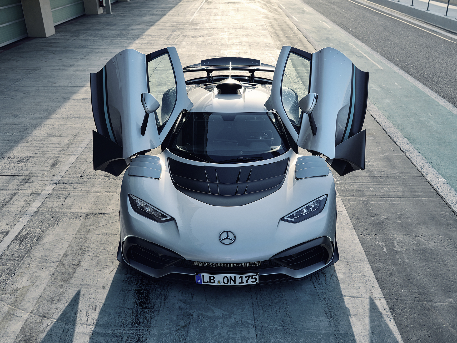 Exteriör | ONE | Mercedes-AMG Mercedes-AMG ONE sedd framifrån med dörrarna öppna.
