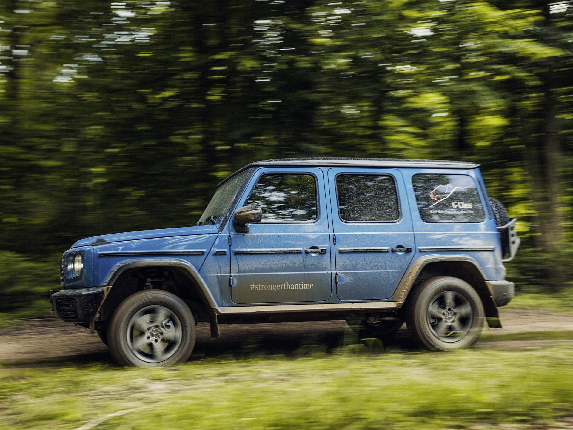 Mercedes-Benz G-Klass kör i skogsterräng.