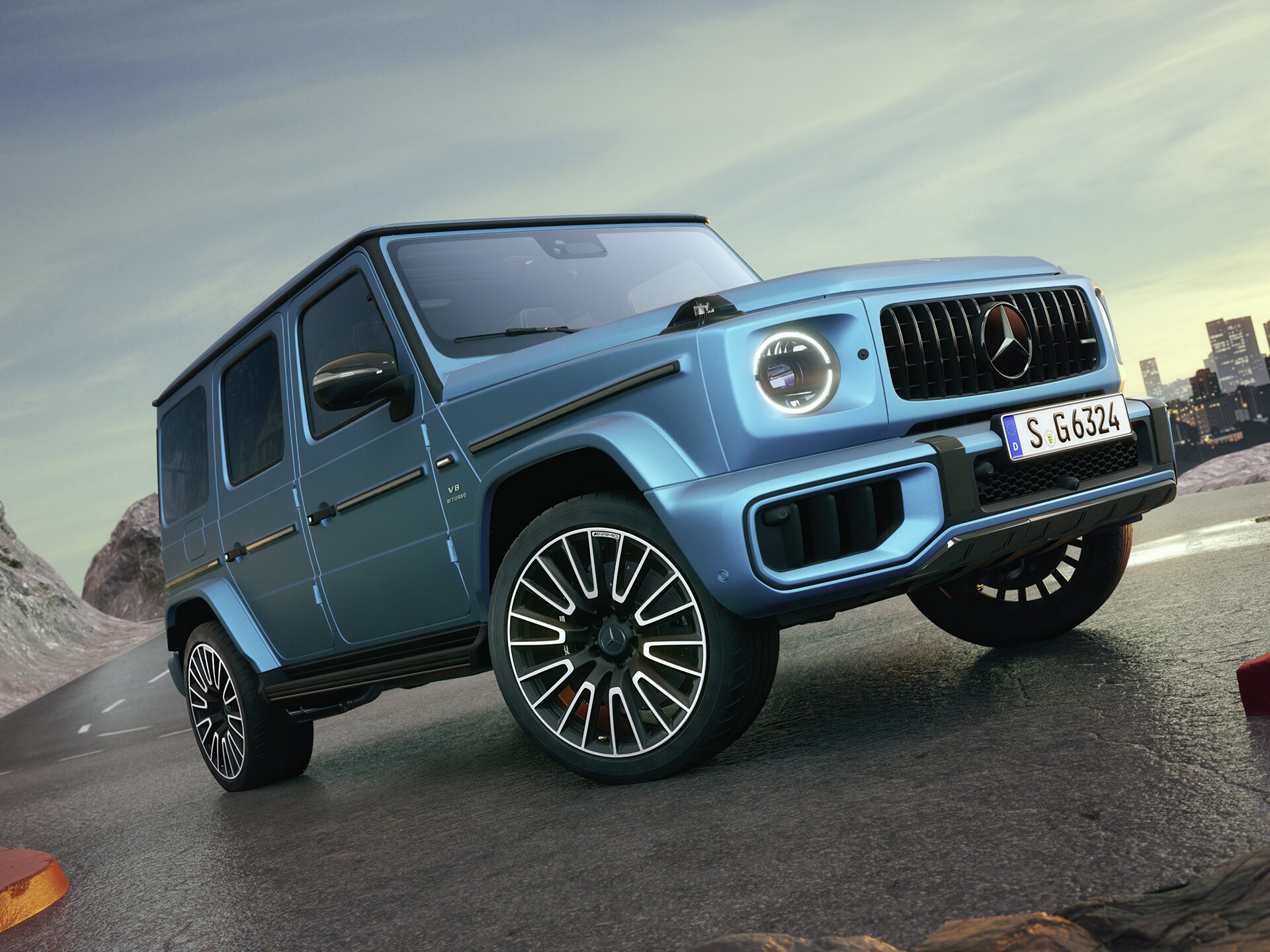 Blå Mercedes-AMG G-Klass sedd snett framifrån på en bergsstigning.