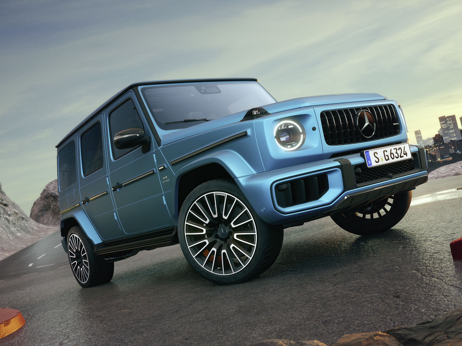 Mercedes-AMG G-Klass | G-Klass Brand Area | Mercedes-Benz Blå Mercedes-AMG G-Klass sedd snett framifrån på en bergsstigning.