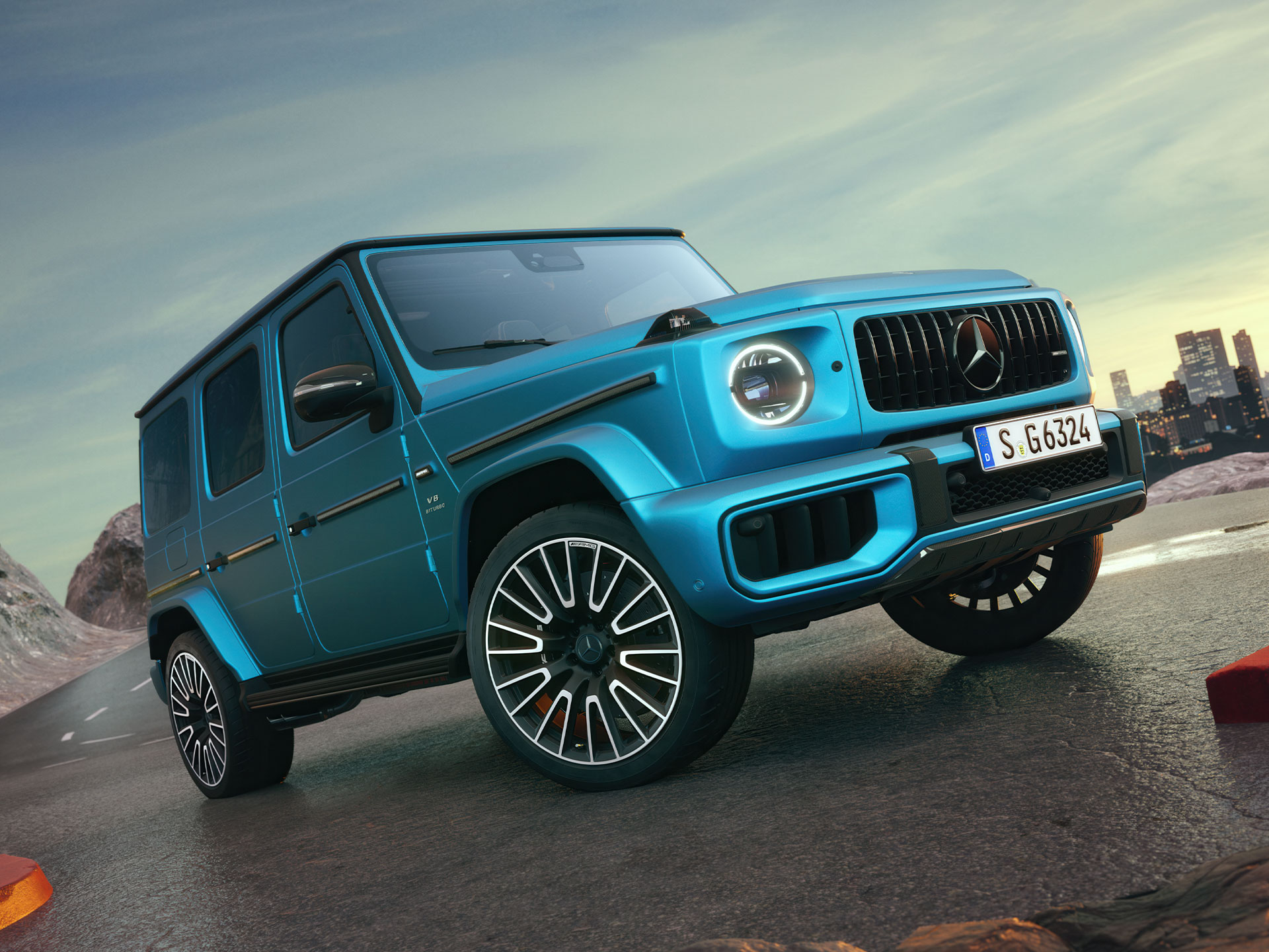 Mercedes-AMG G-Klass | G-Klass Brand Area | Mercedes-Benz Blå Mercedes-AMG G-Klass sedd snett framifrån på en bergsstigning.