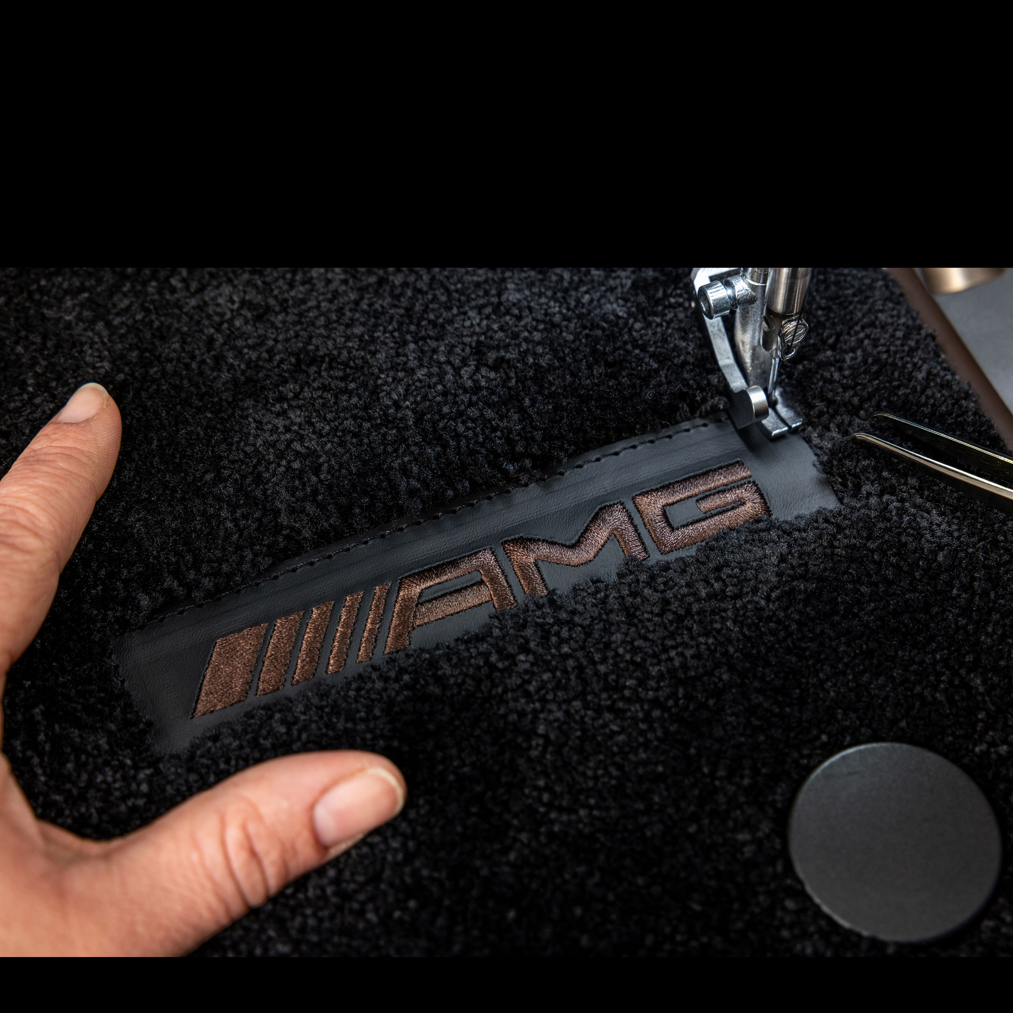 MANUFAKTUR | Mercedes-AMG Texten MANUFAKTUR på en mörk yta i en Mercedes-AMG.