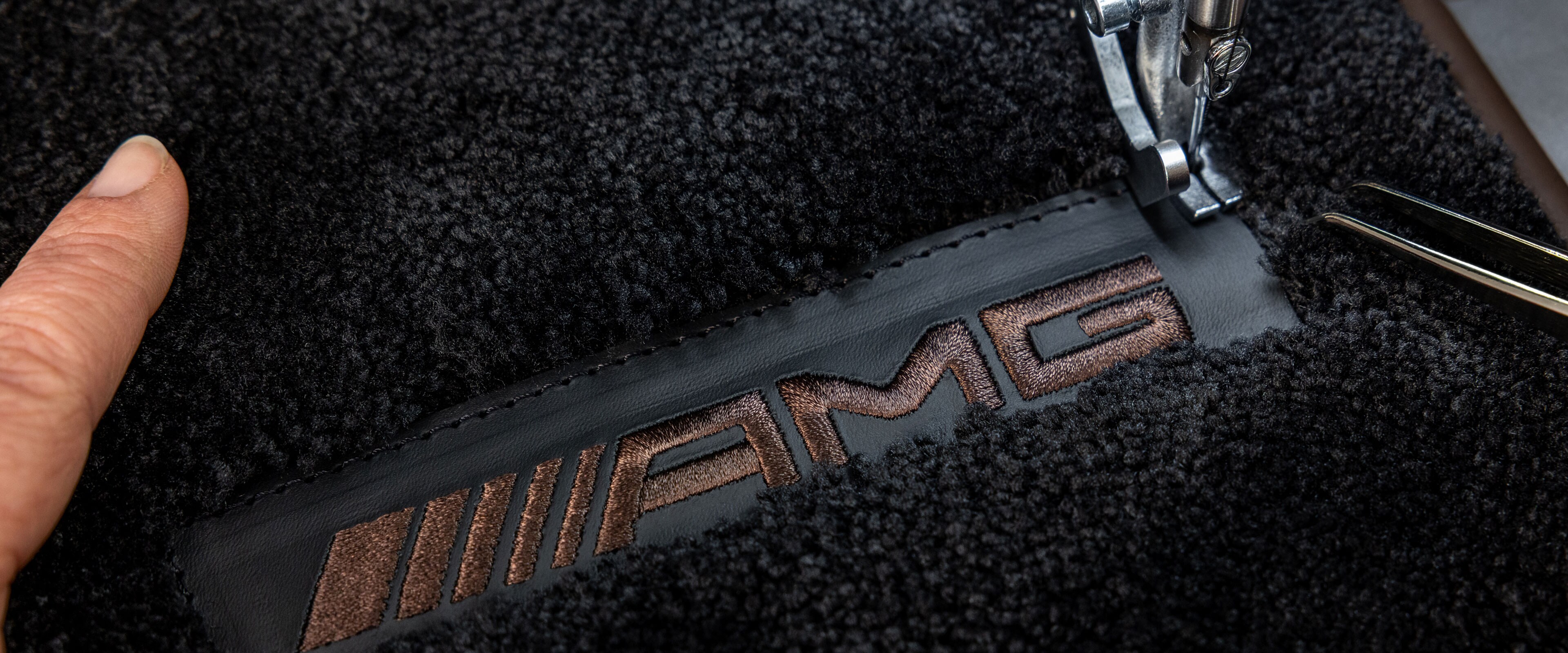 Texten MANUFAKTUR på en mörk yta i en Mercedes-AMG.