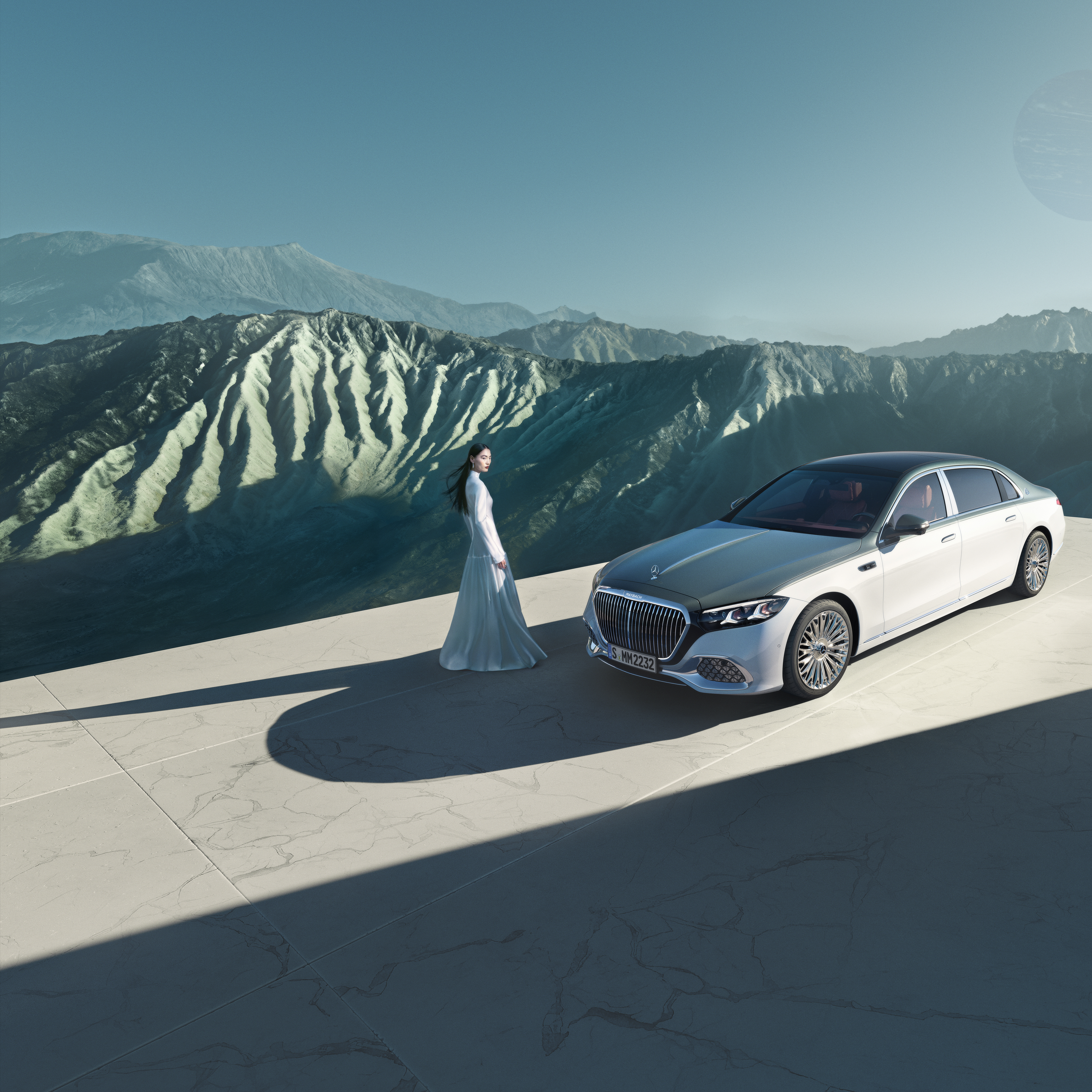 Märket | Mercedes-Maybach Kvinna står framför en Mercedes-Maybach med tvåfärgad lackering.