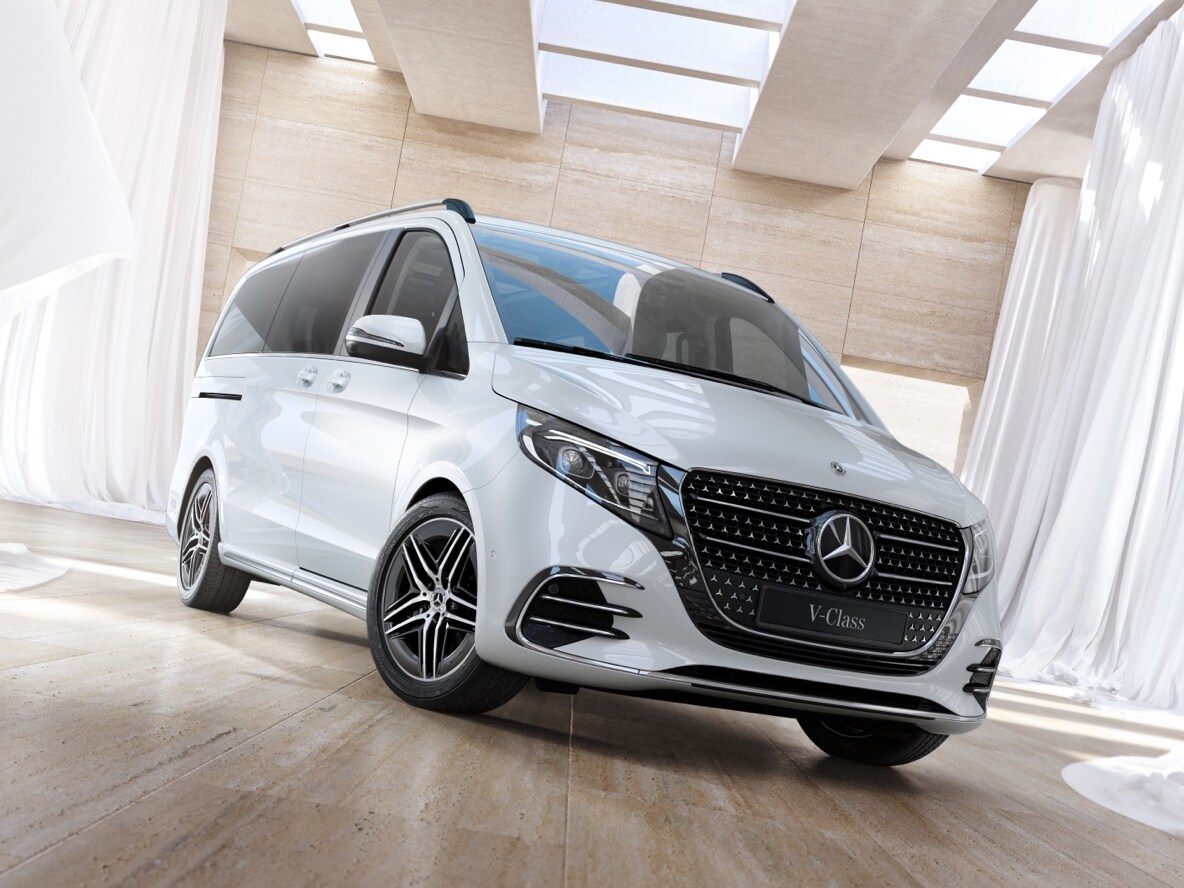 En vit Mercedes-Benz V-Klass står parkerad på parkettgolv i träd. 