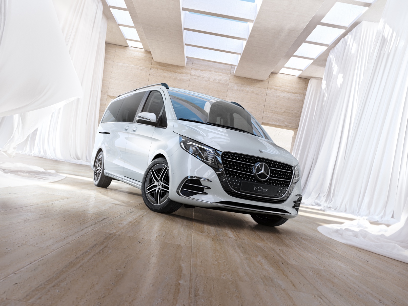 V-Klass minibuss från Mercedes-Benz En vit Mercedes-Benz V-Klass står parkerad på parkettgolv i träd.