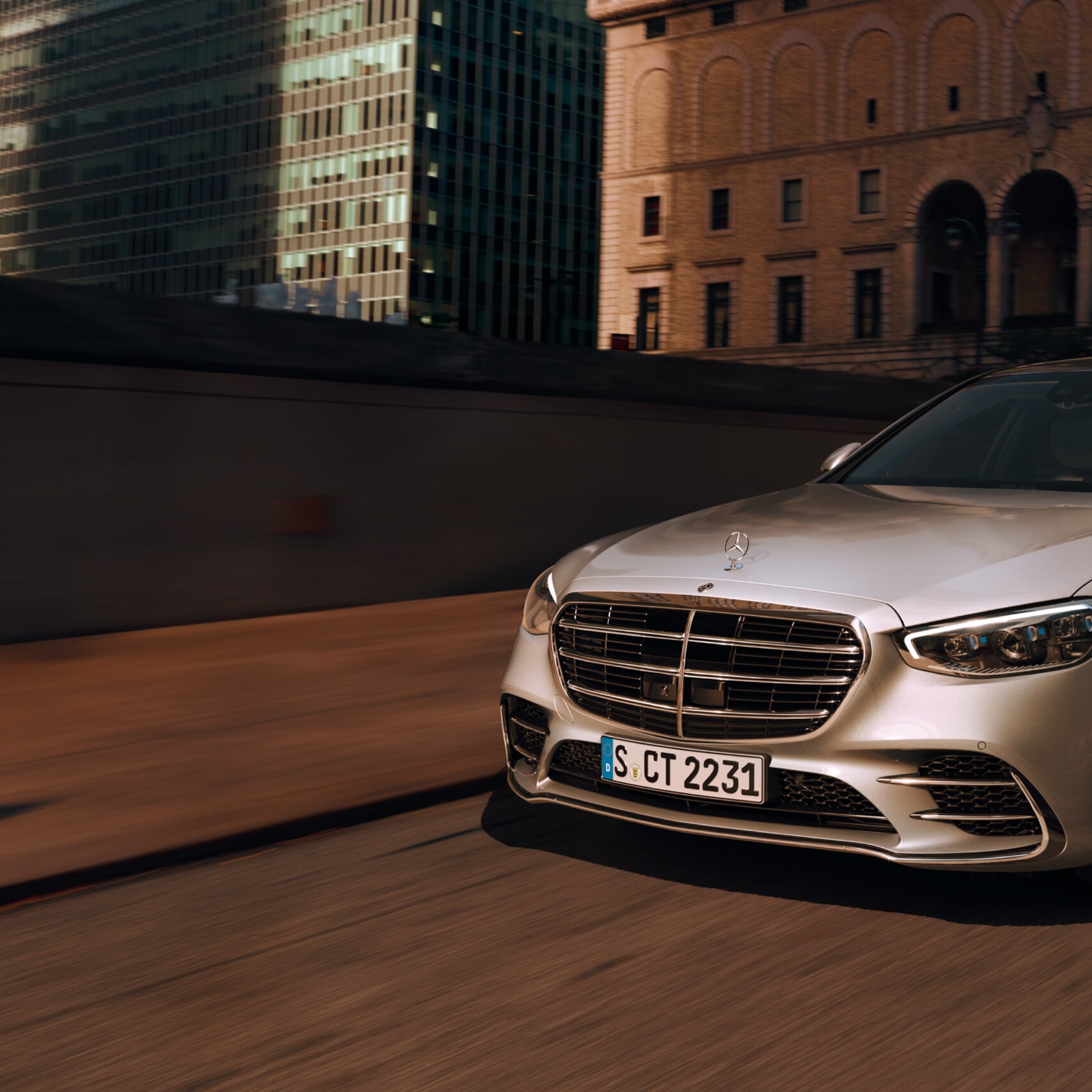 Mercedes-Benz S-Klass i silver som kör på en väg, sedd framifrån