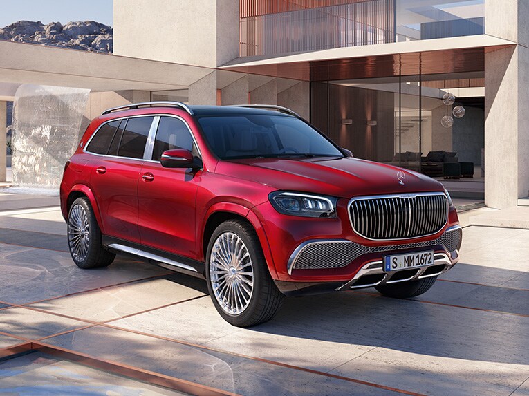 Röd Mercedes-Maybach GLS parkerad framför ett modernt hus
