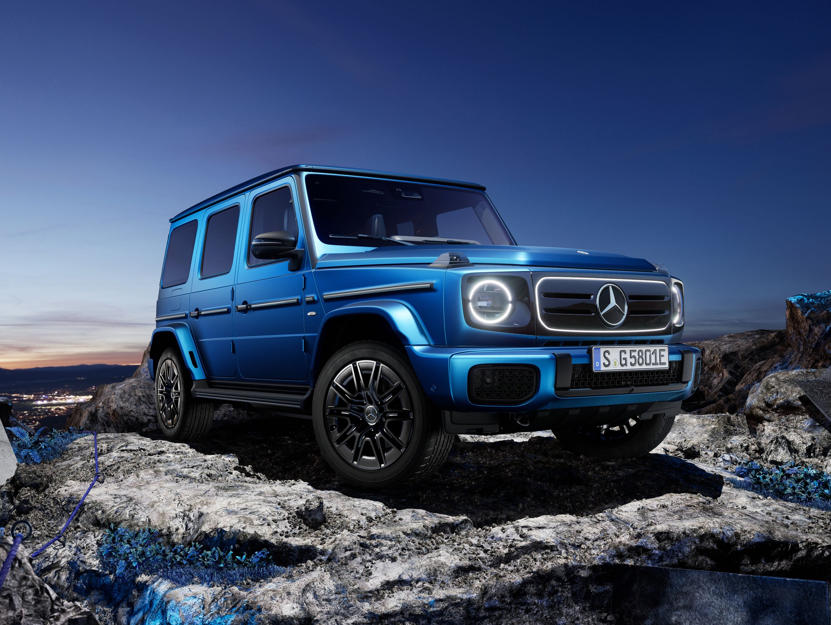 En blå helelektrisk Mercedes-Benz G-Klass står i terräng