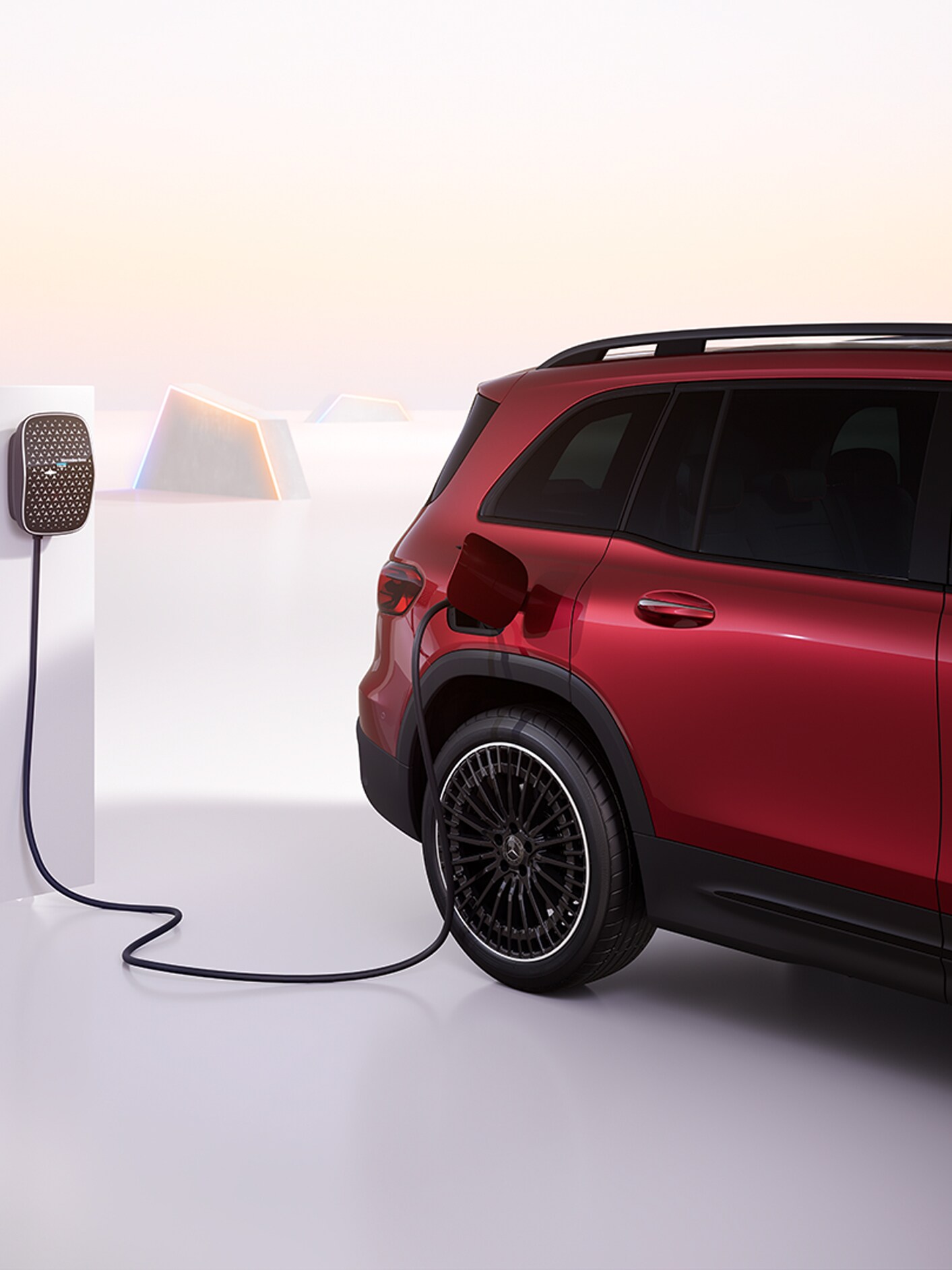 En röd Mercedes-Benz EQE SUV laddas vid en Mercedes-Benz väggmonterad laddbox